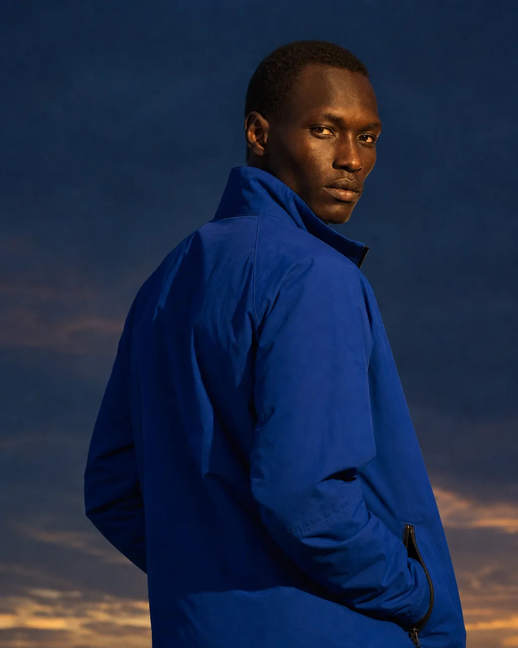 A model looking back over the shoulder against a golden dusk sky in the SF-01.
