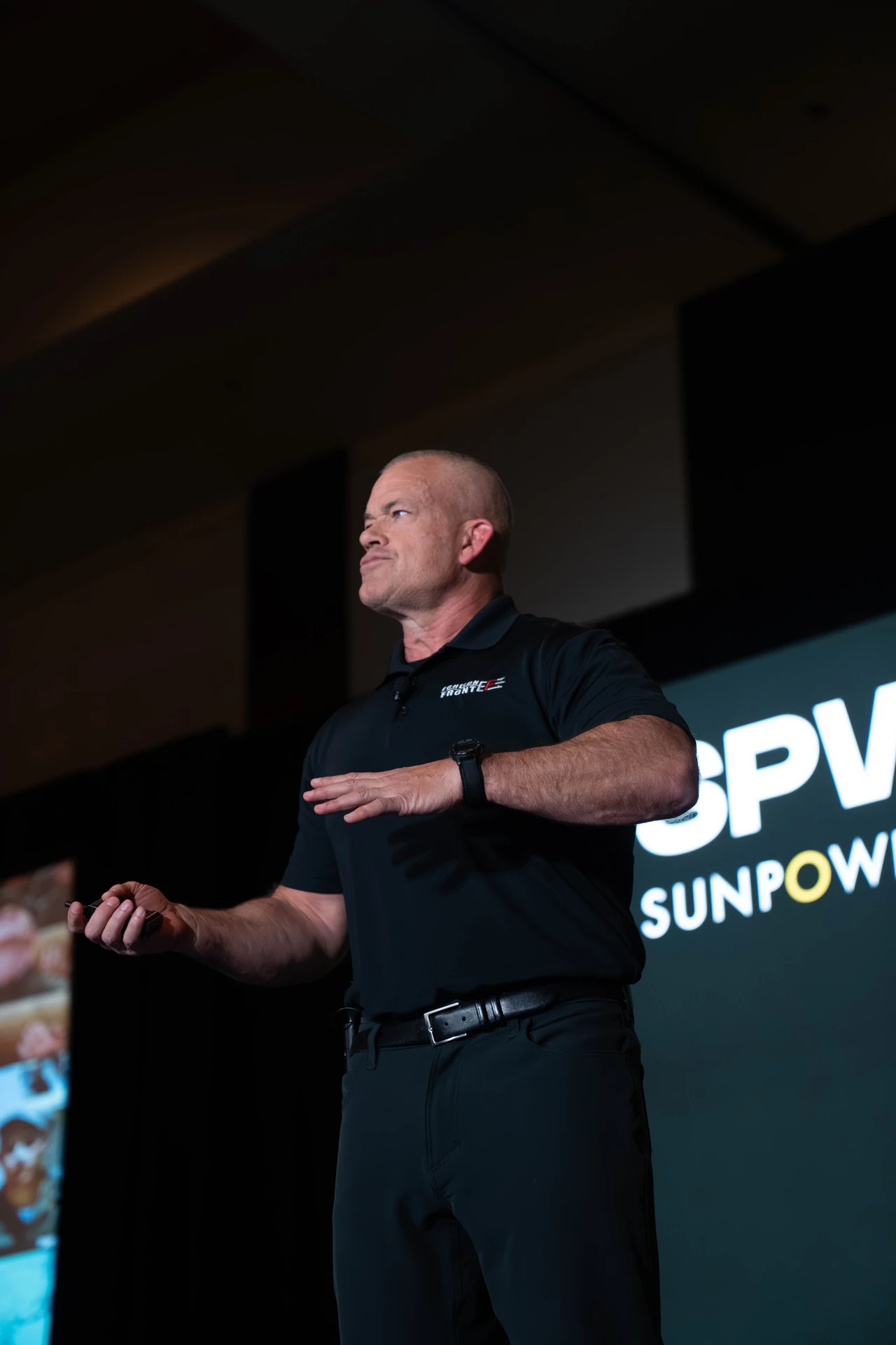 Speaker on stage with the SPWR and SunPower backdrop visible behind him.