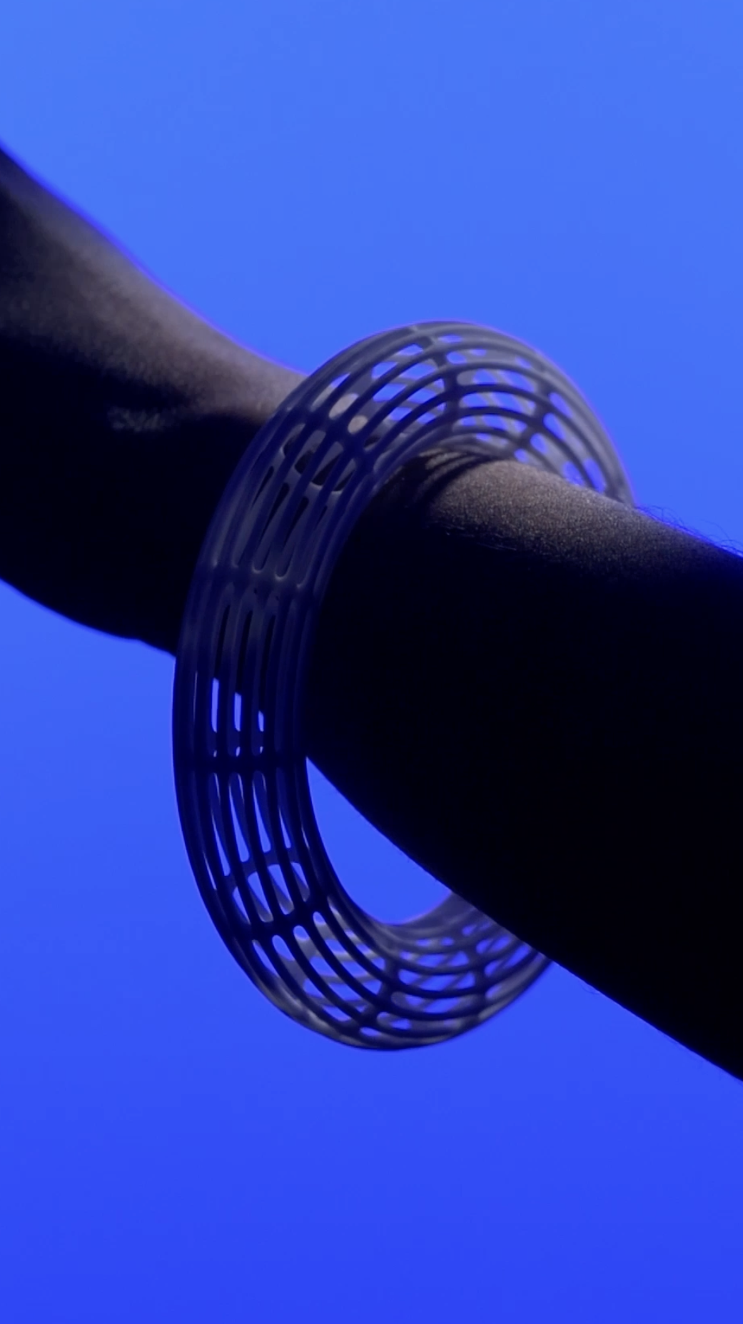 Close-up of a ceramic bracelet from the Ceramica Collection, designed by Sebastian Renga for Ceramaret — captured against a deep blue background.
