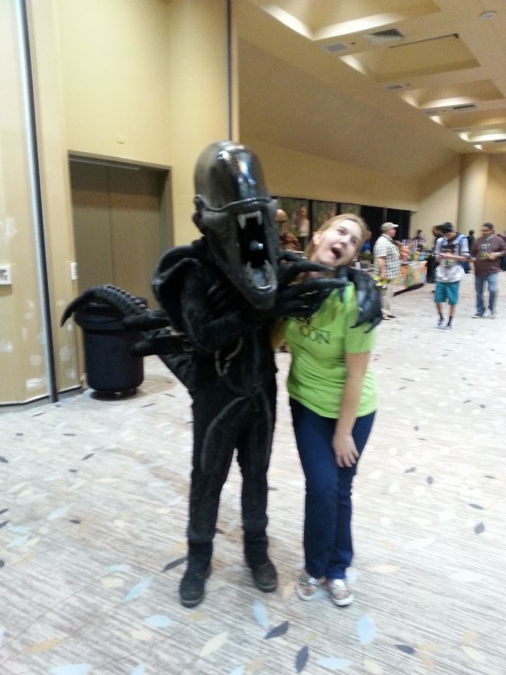 an alien con staff member pictured taking a goofy photo with someone dressed as a xenomorph from Alien
