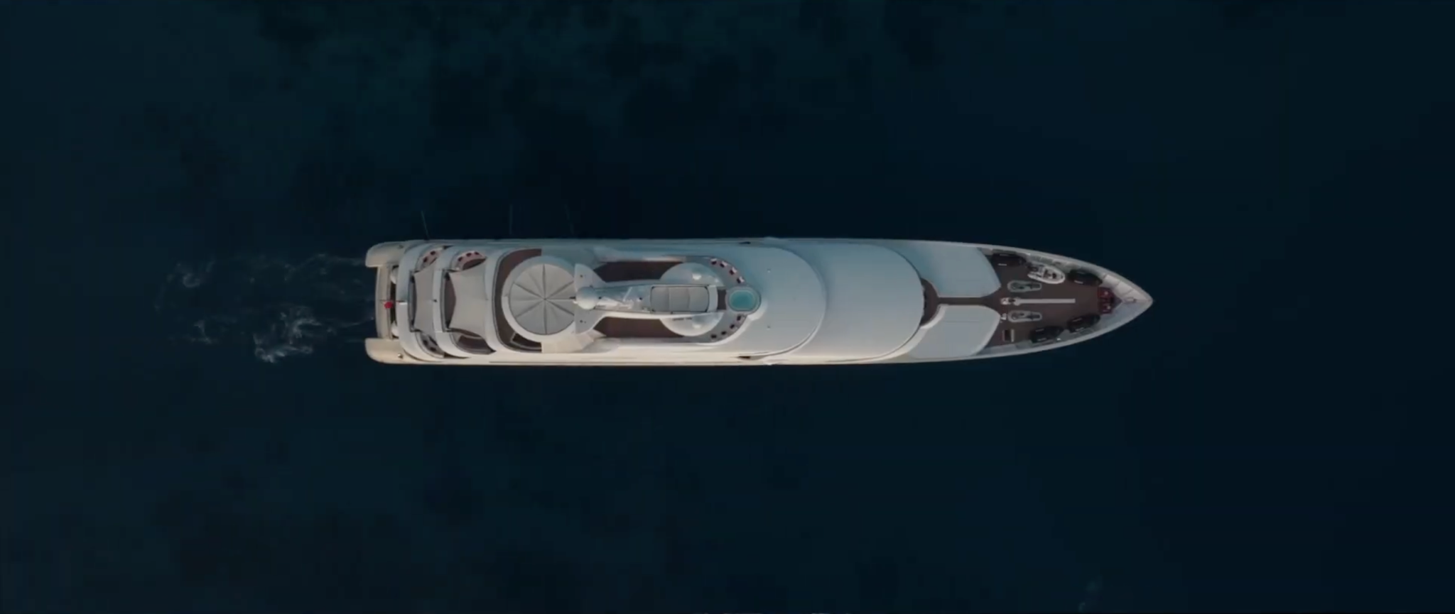 Aerial view of a yacht cruising through deep blue water
