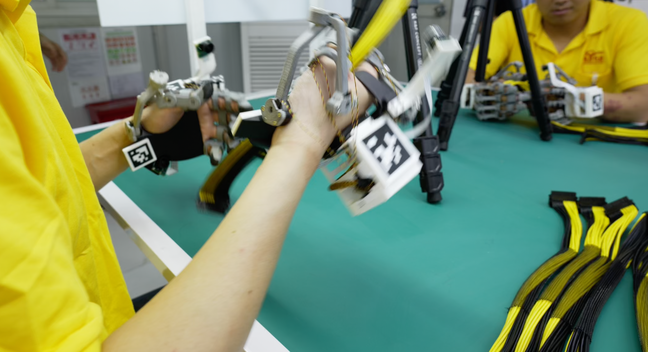 Close-up of the earlier glove being used to handle cables at the workbench.