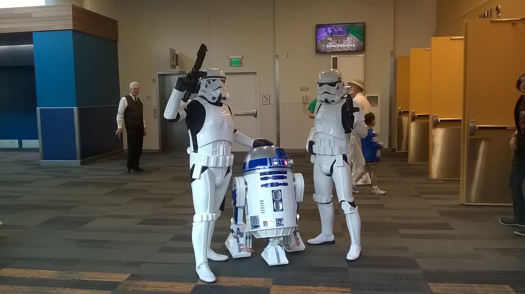 two silicon valley comic con guests cosplaying storm troopers with a fully operable R2D2