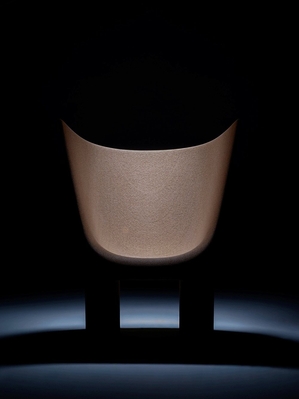 Animated GIF showing the front view of the Materia Futura chair in Econit Wood — light revealing the sculptural texture and curvature.