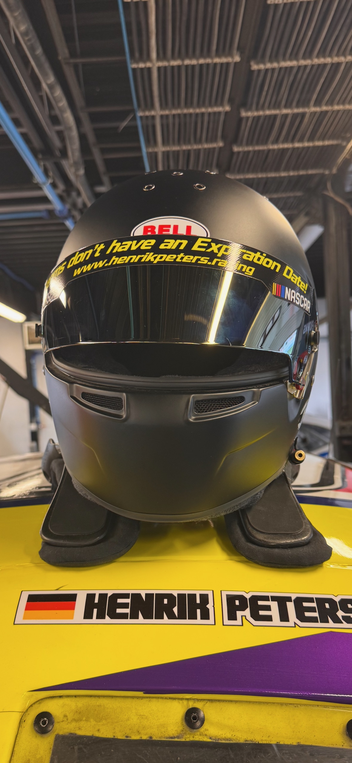 Black Bell helmet on Car Number 50 with Dreams don't have an Expiration Date motto and Henrik Peters name