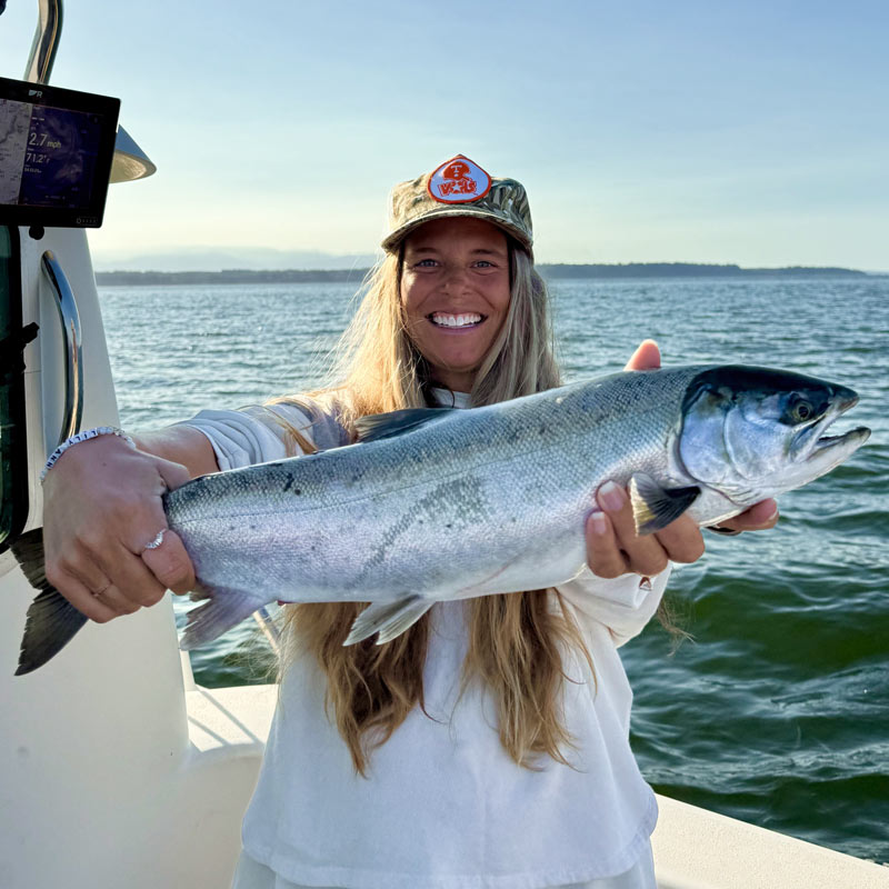 Woman on a boat holding a salmon