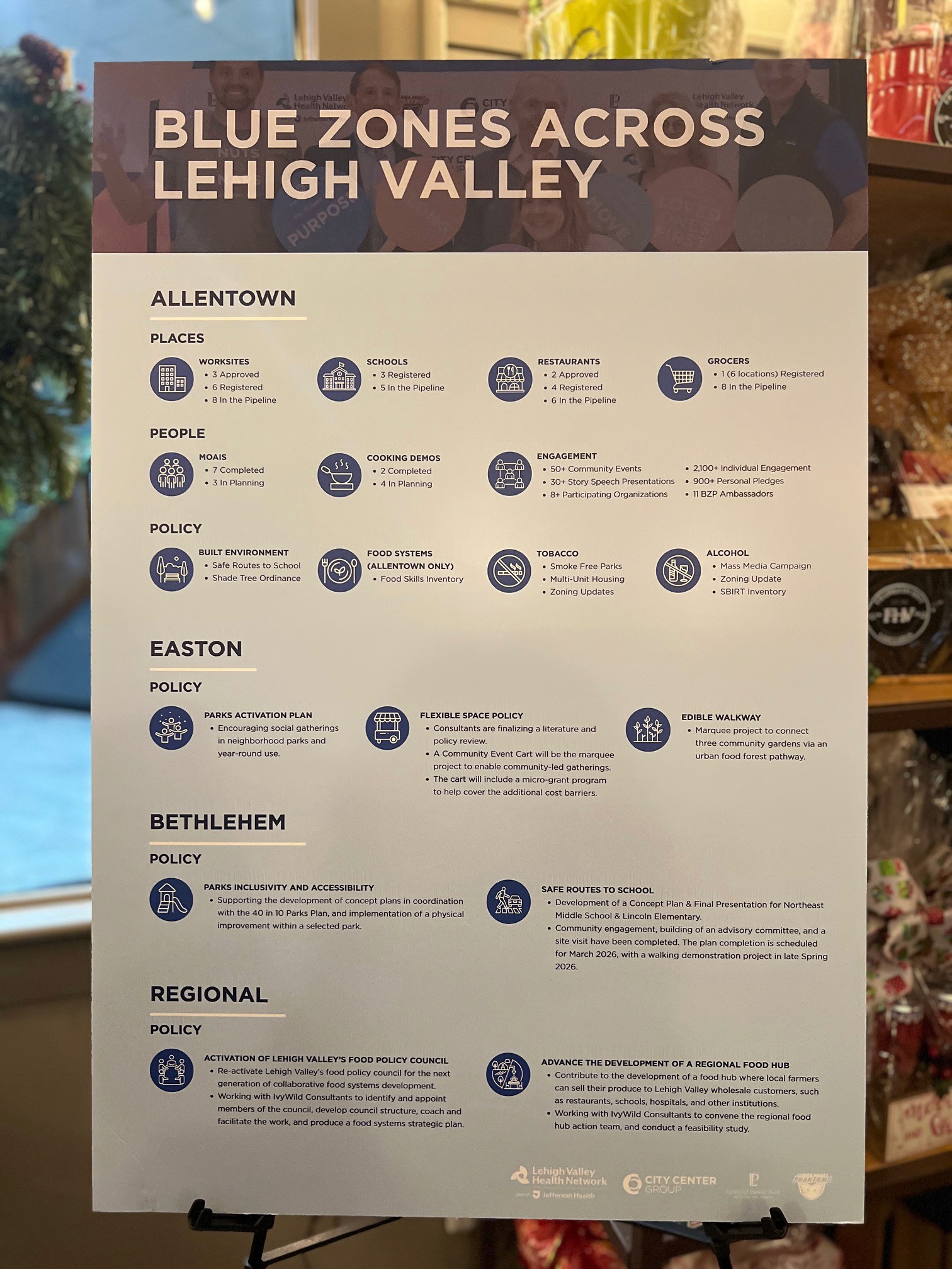 Modern home office setup with a monitor, ergonomic chair, keyboard, and indoor plants near a window with blinds.