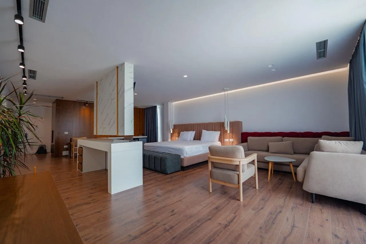 woman looking at brown giraffe with reflection on water