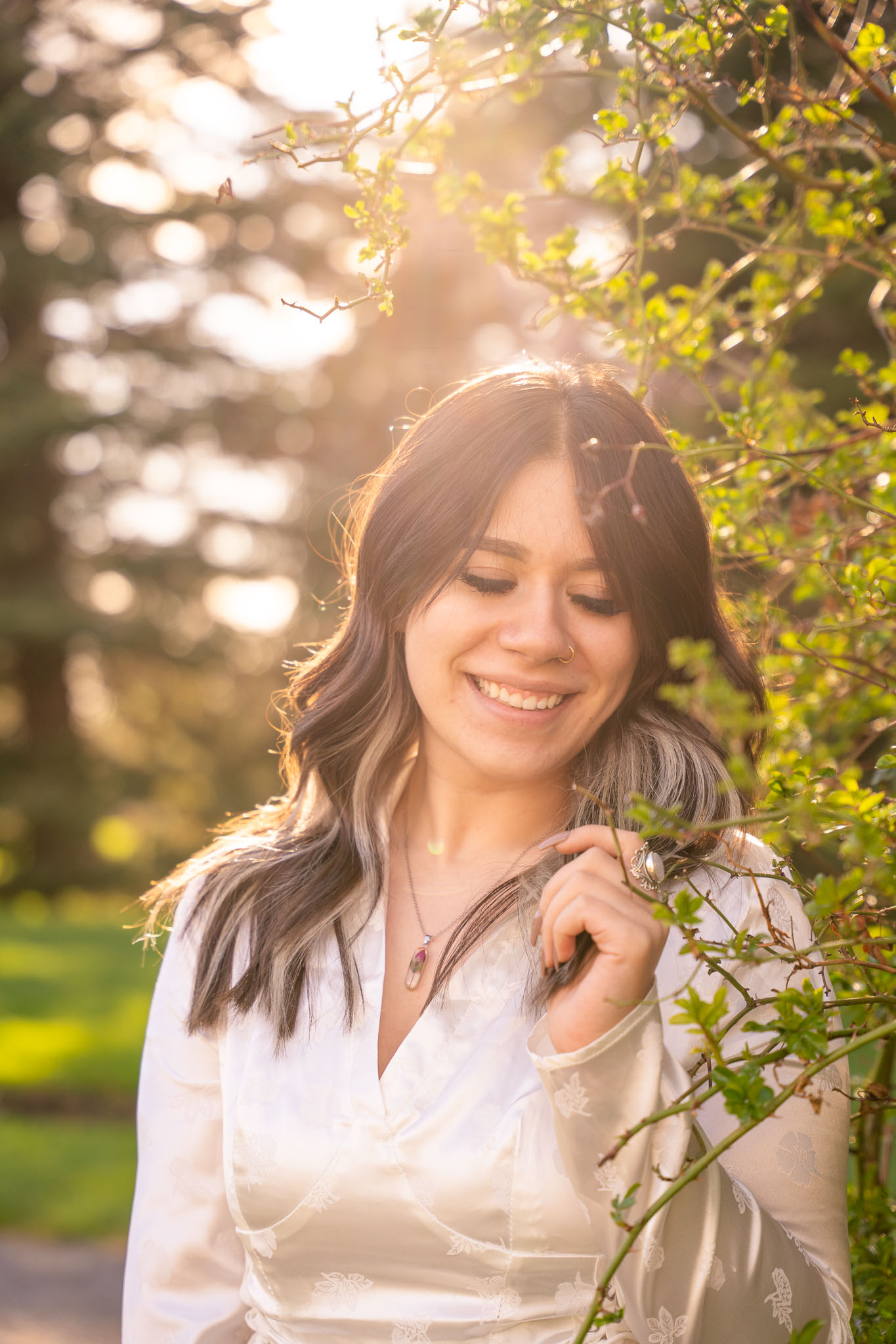 portrait of a woman with the sun gently hitting from the back and her grabbing a piece of her hair