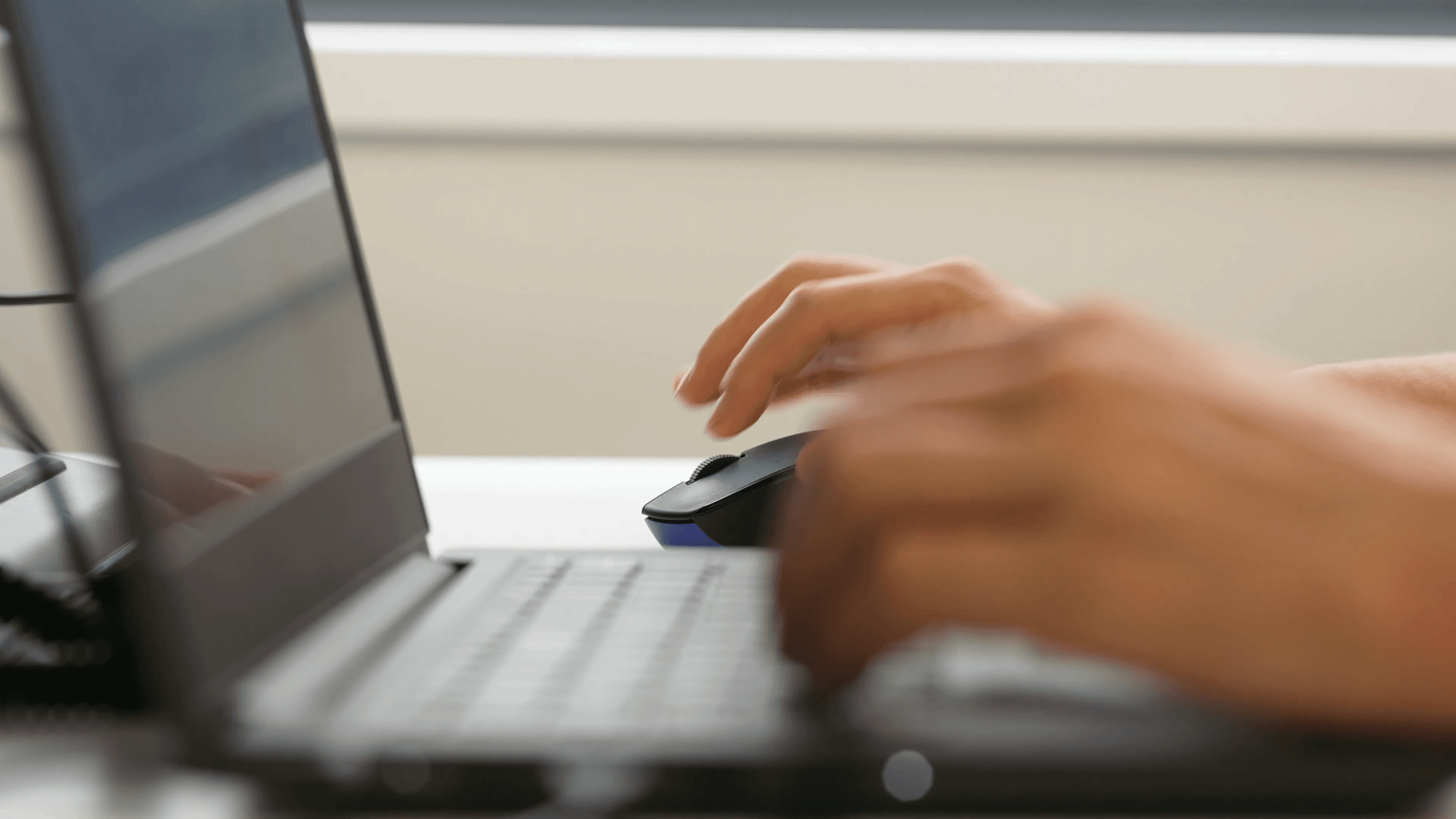 image of light coloured hands working on a grey laptop