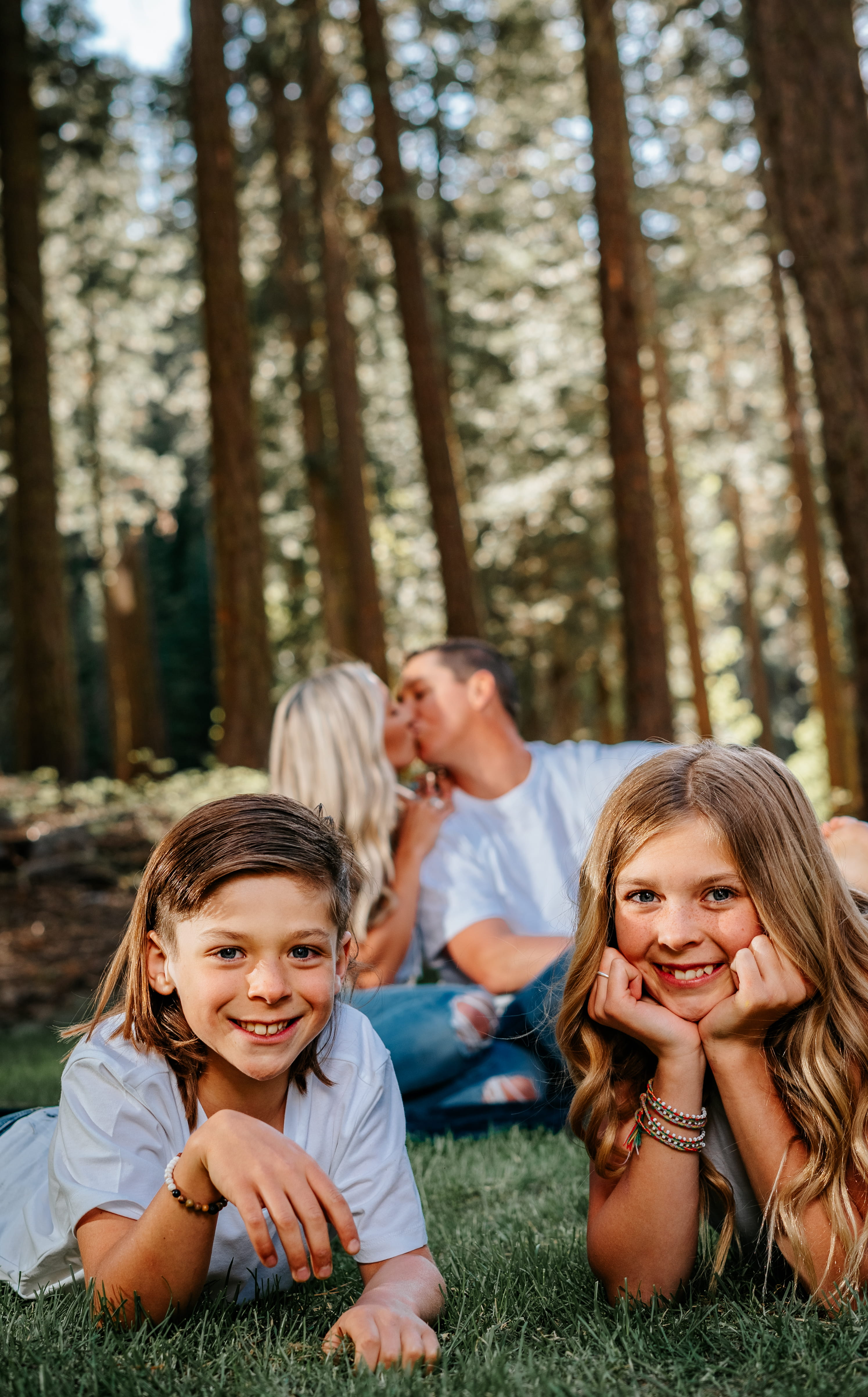 A couple in wedding attire walks hand in hand across a sunlit field.