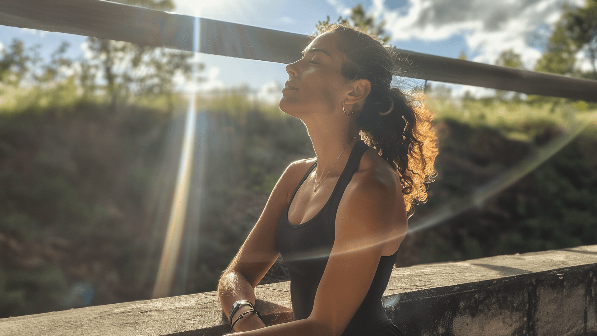 Eine junge, athletische Frau im schwarzen Top stützt sich an einer grauen Mauer. Ihre Augen sind geschlossen und sie nimmt sich eine kleine Pause von ihrem Lauftraining.