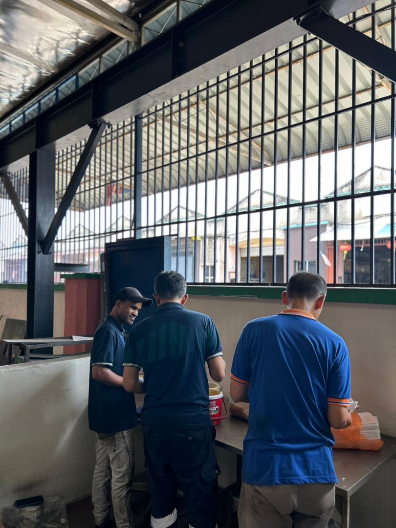 Employees serving themselves during the Deepavali team lunch in the factory setting.