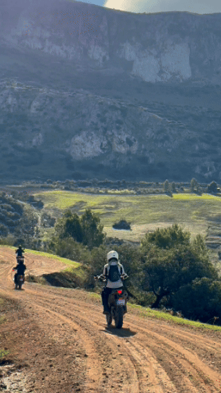 Эндуро мотоцикл едет вдоль побережья Испании на закате — тур Lepei.tours, свобода, море и приключение.