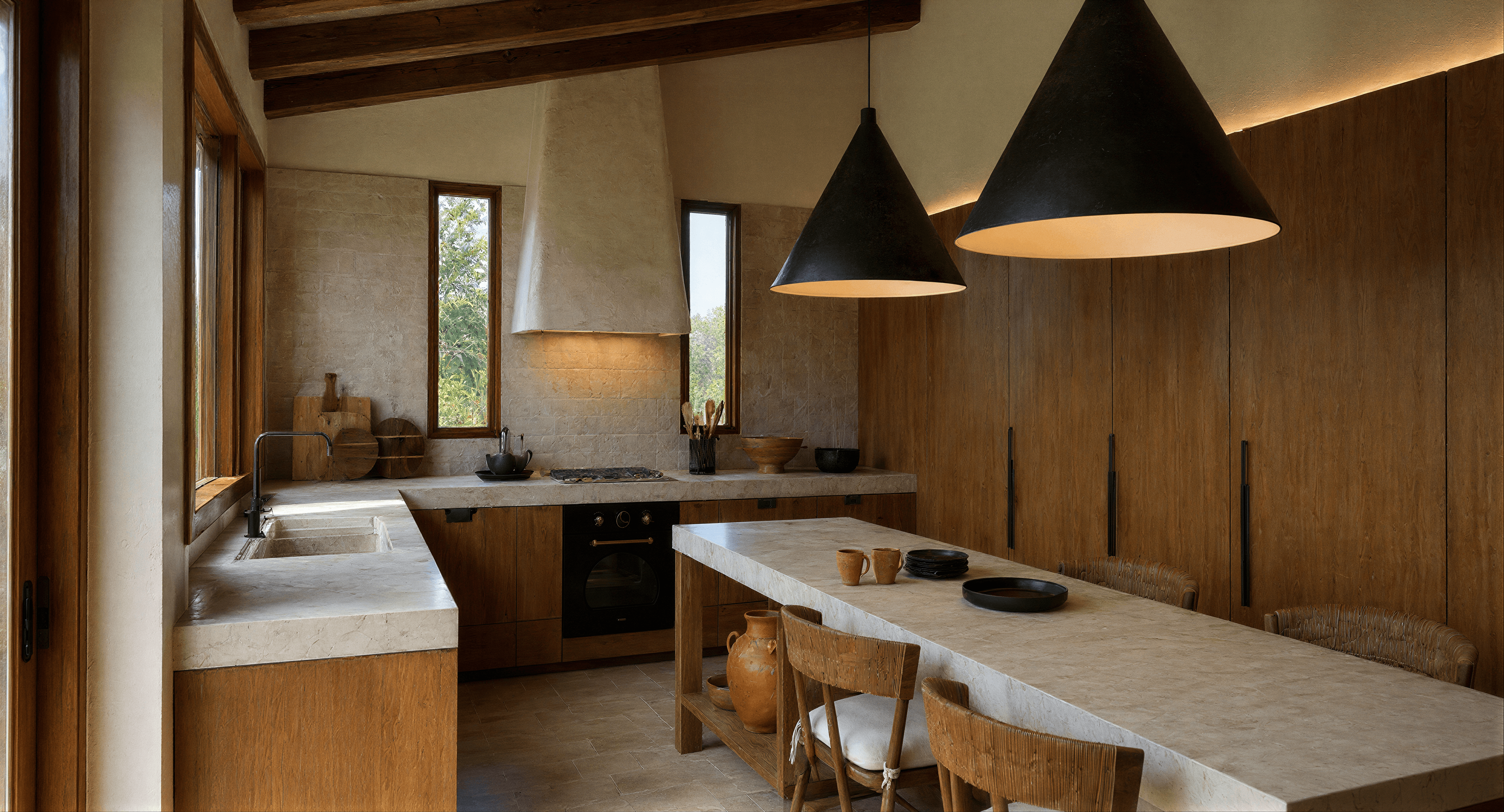 Cocina y comedor con mobiliario de madera y materiales naturales.