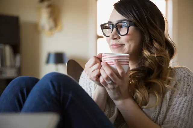 Mujer disfrutando de tranquilidad en casa tras descubrir cuánto ahorra al cambiar el seguro de vida de su hipoteca