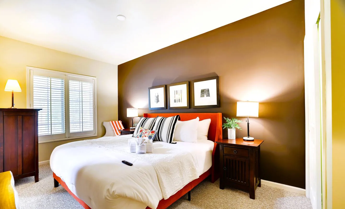 Main floor king bedroom with brown accent wall and framed art at Pop's Place
