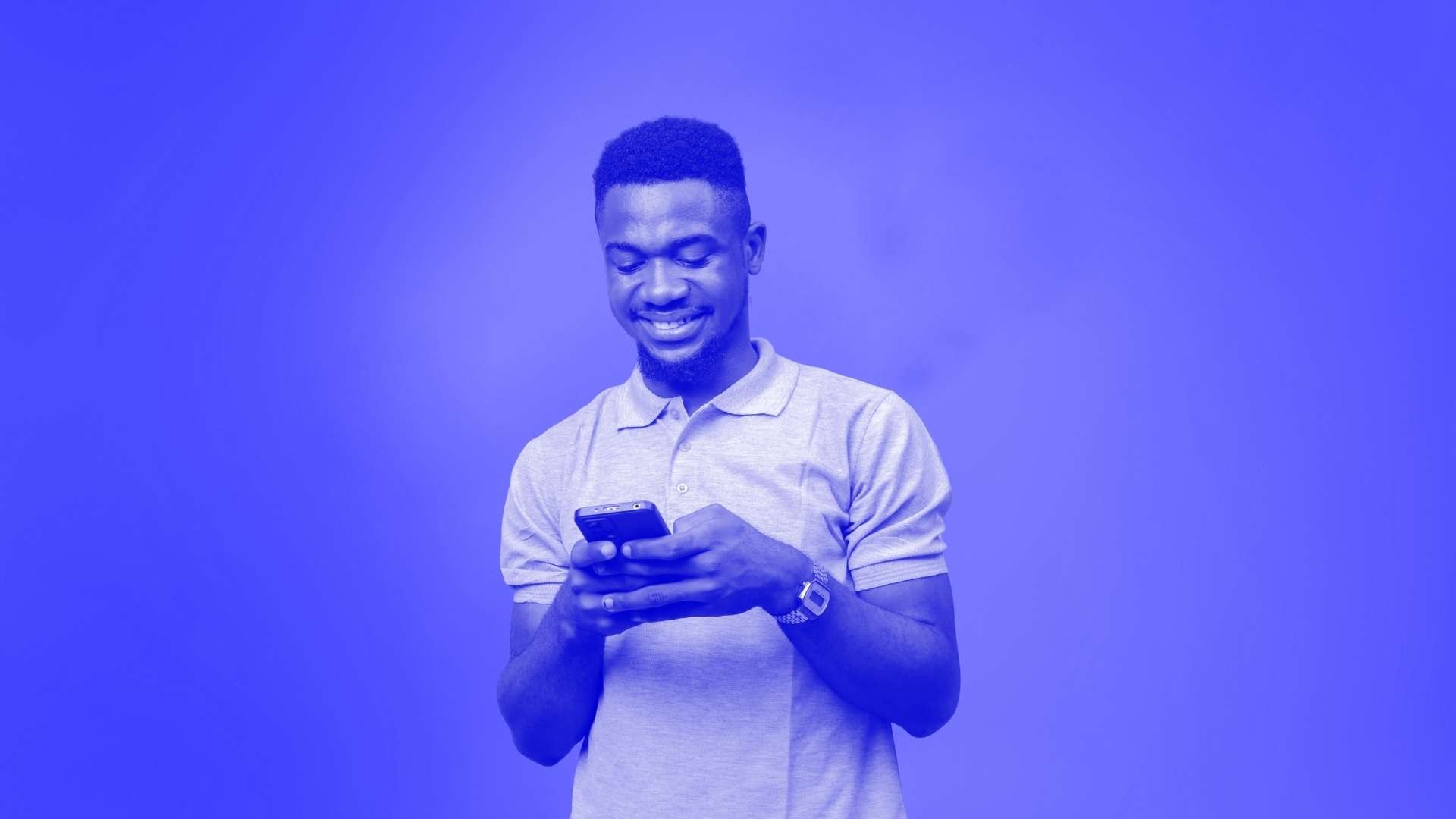 Happy man looking at and using his smartphone