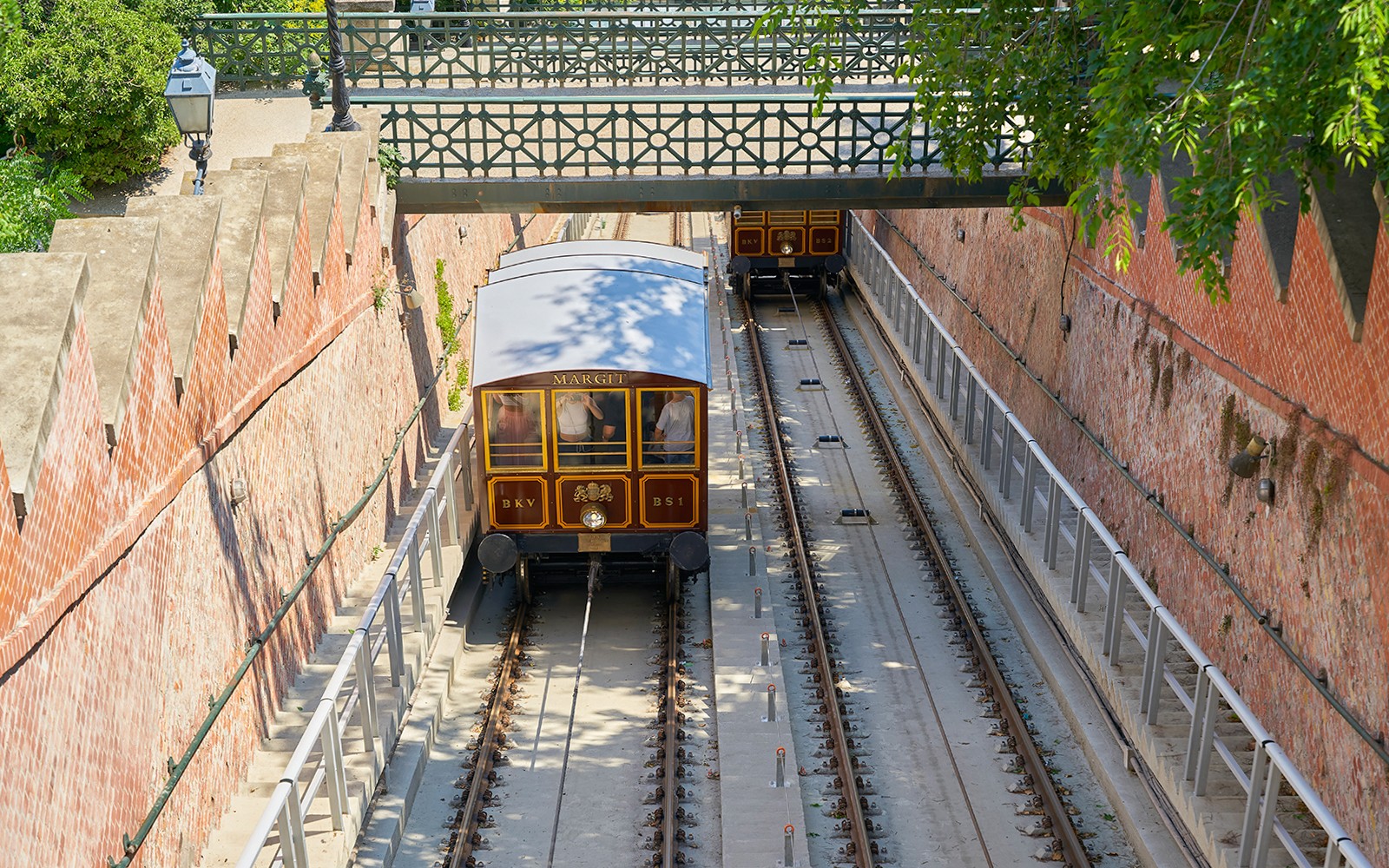 Budapest cityscape with red hop-on hop-off bus and Danube River boat tour.