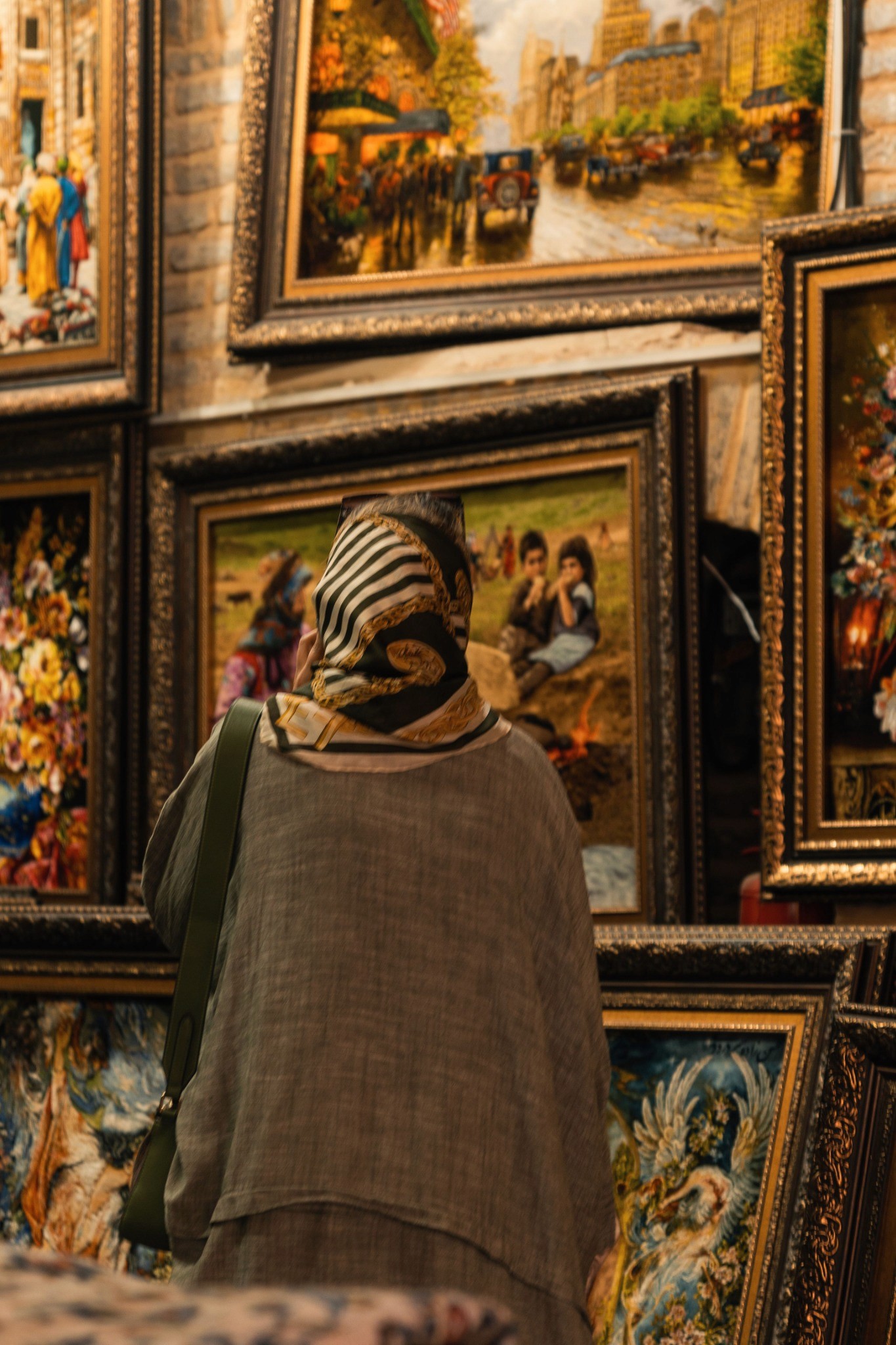 A woman taking in a richly layered art display