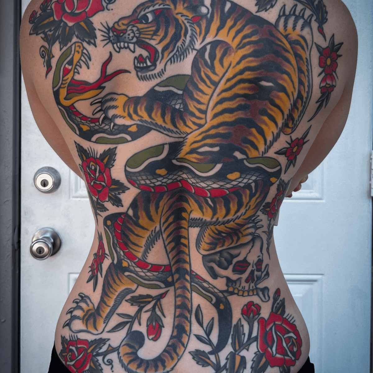 large back tatoo with a tiger fighting a snake