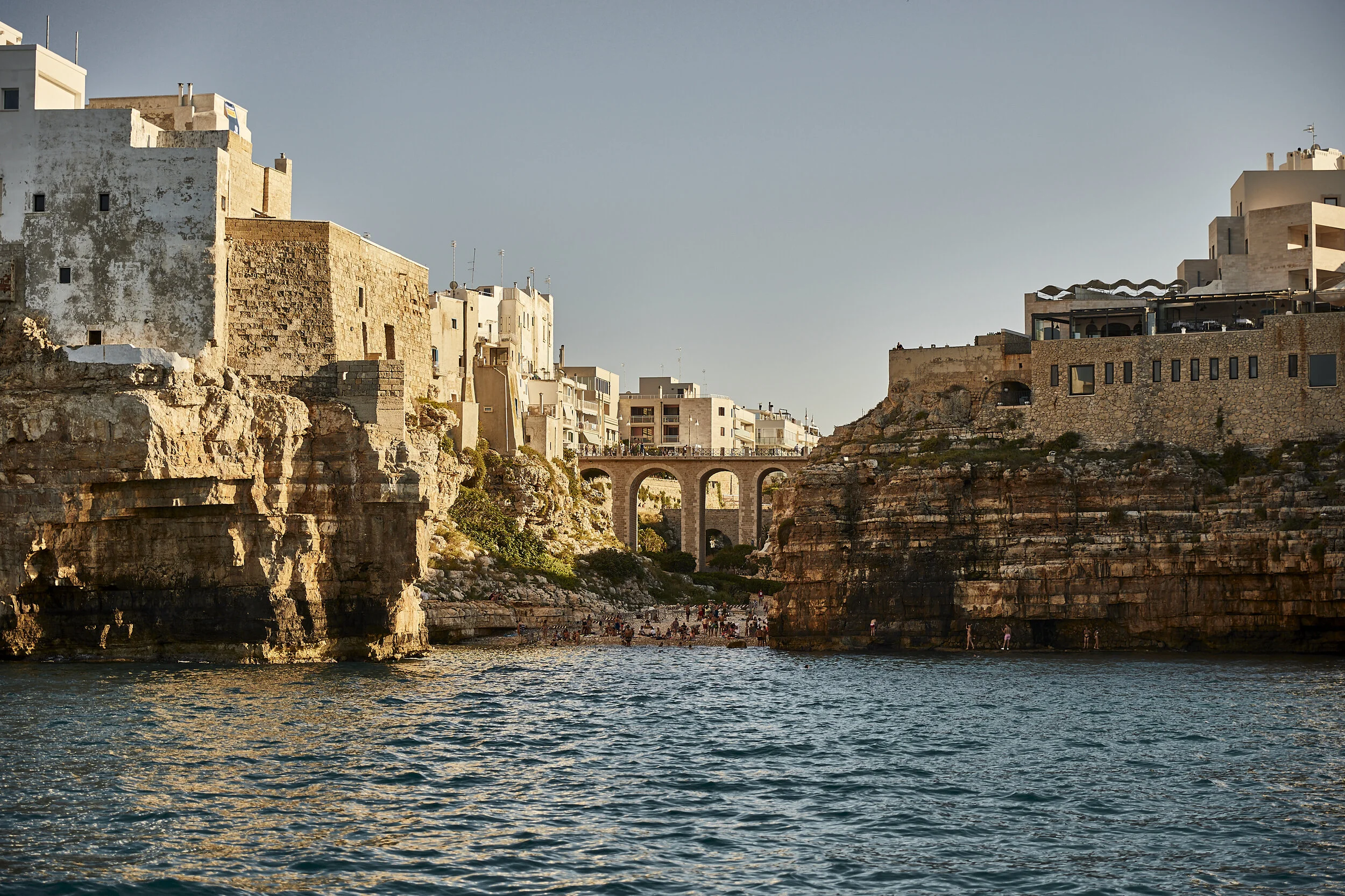 Luftaufnahme eines Hotels mit Swimmingpool, Rasenfläche und weißen Gebäuden unter blauem Himmel.