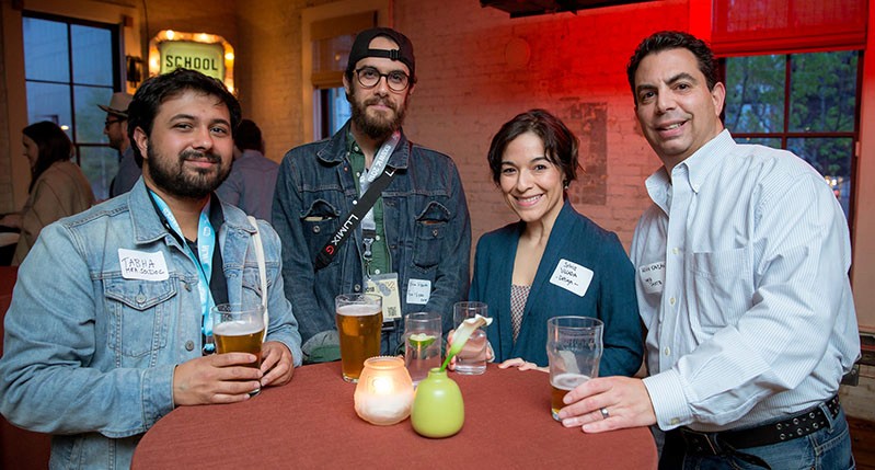 A photo of a group of people sitting at a table and drinking beer.