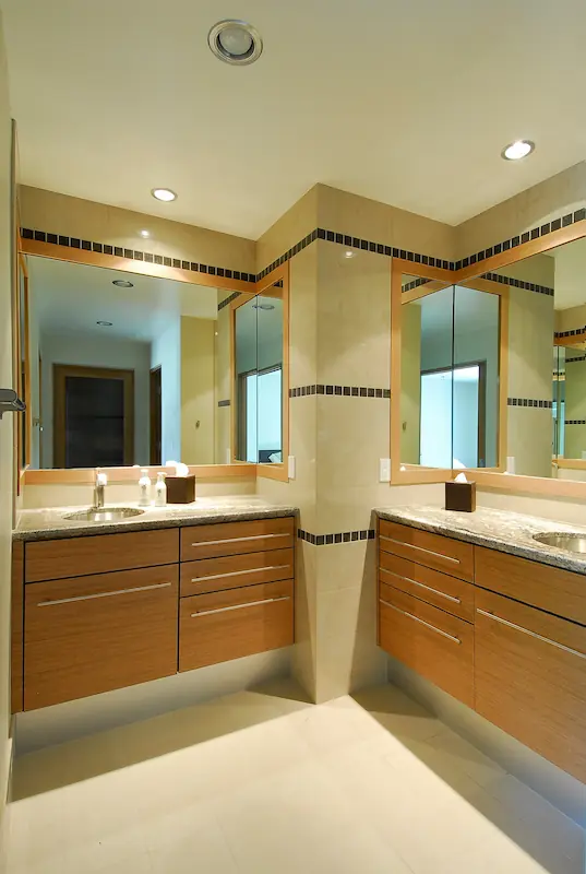Neutral-toned bathroom with wooden cabinets, large mirror, modern fixtures. Part of Irvine Transitional Modern, photo by Chris Darnall.