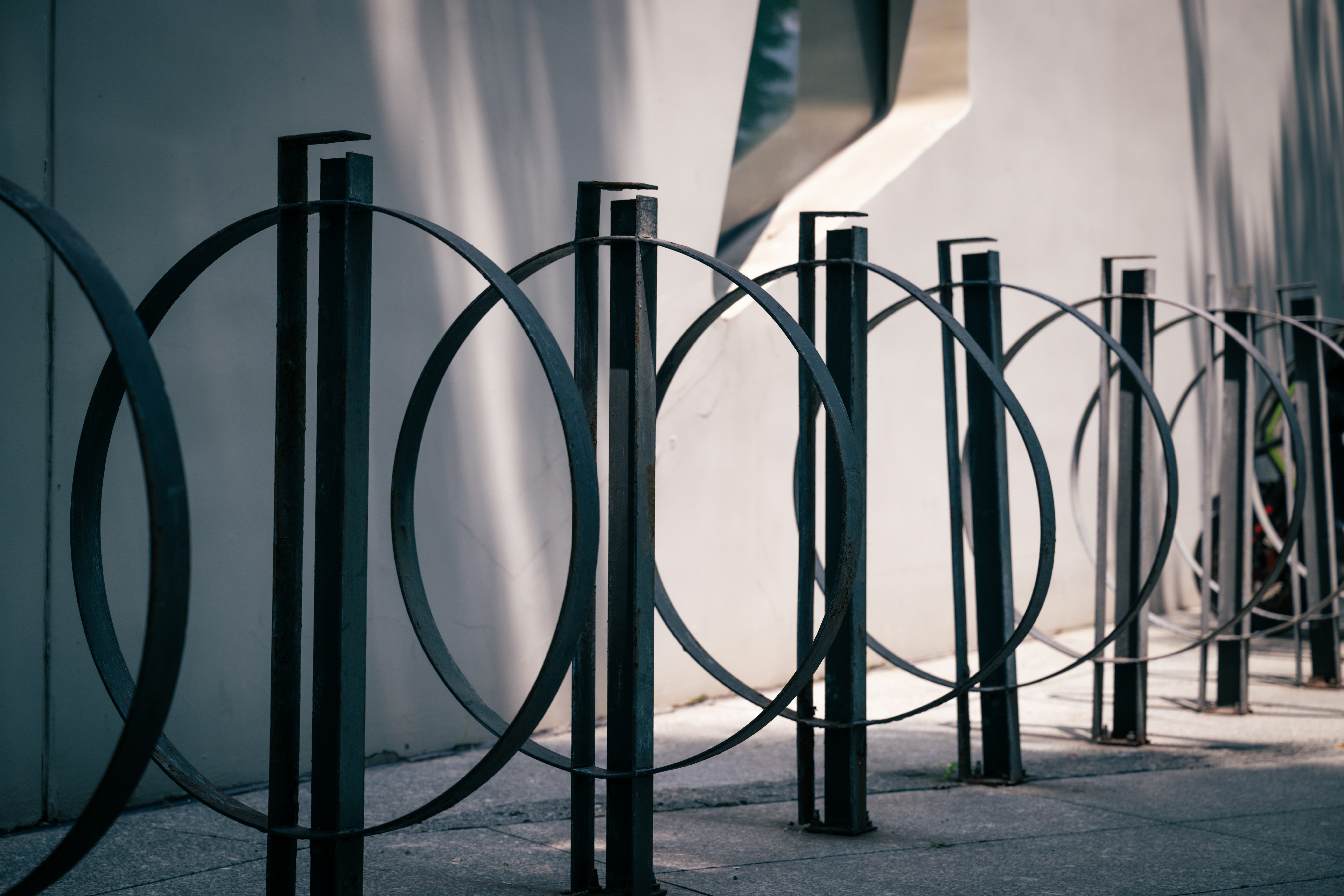 a row of black metal poles next to a building