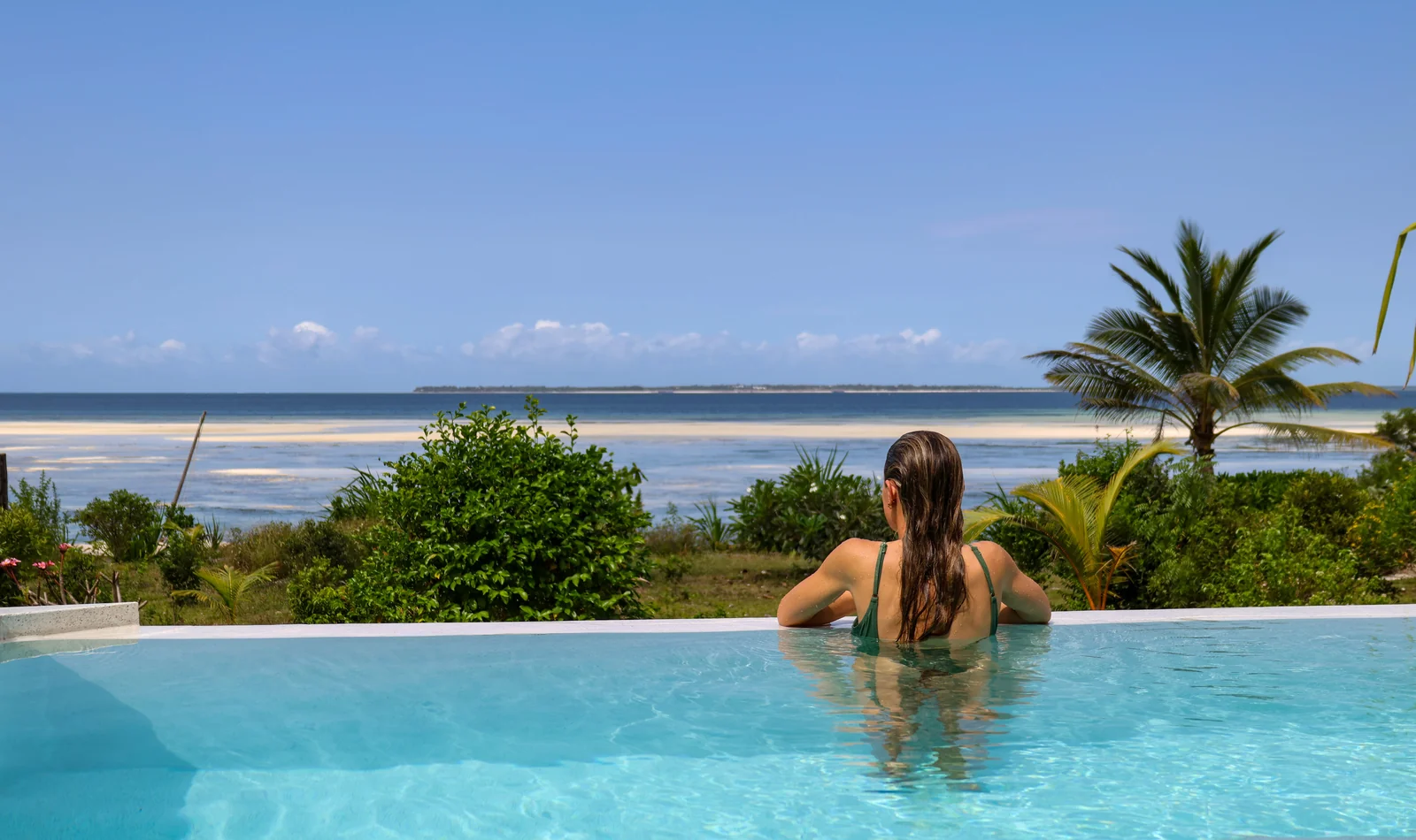a beautiful image of the gardens around the property with the sea in the background