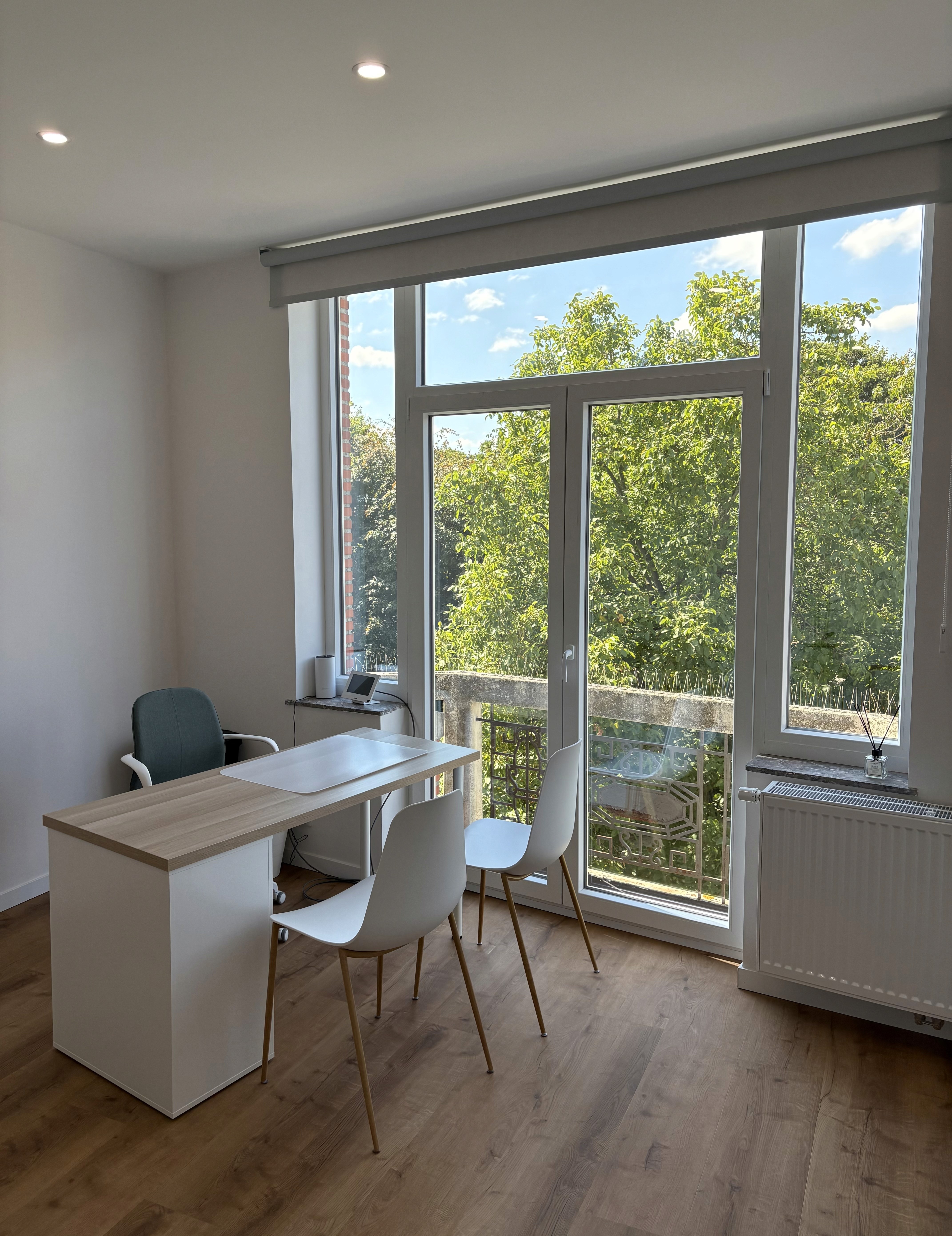 A smiling woman doctor is sitting at her desk and looking at a computer screen showing a medical screening test.