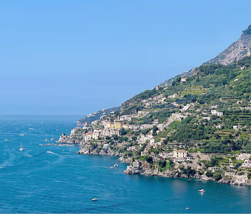 Luxury yacht sailing along the Amalfi Coast cliffs