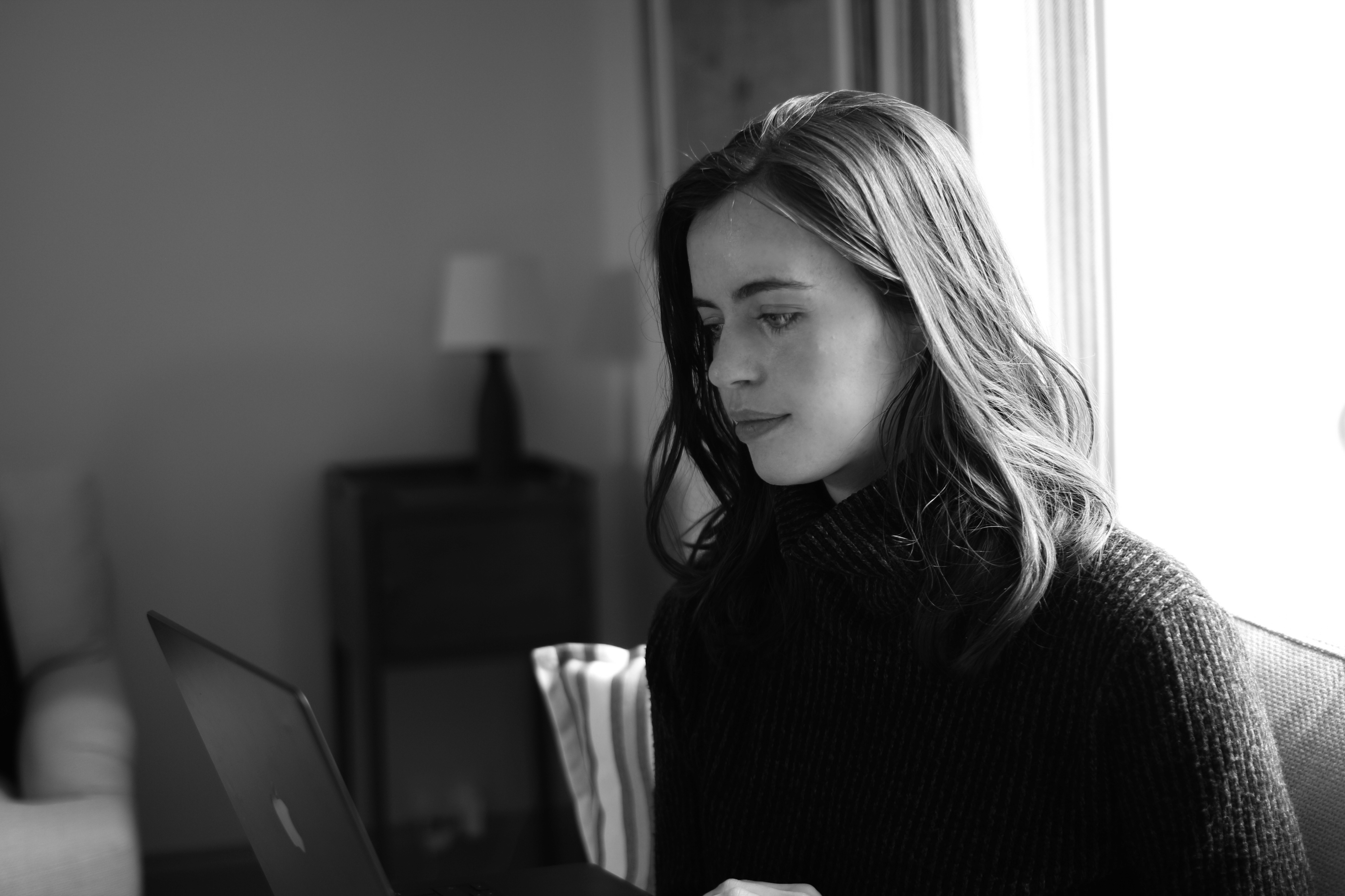 Photograph of Ella Frances working on a graphic design project in her studio