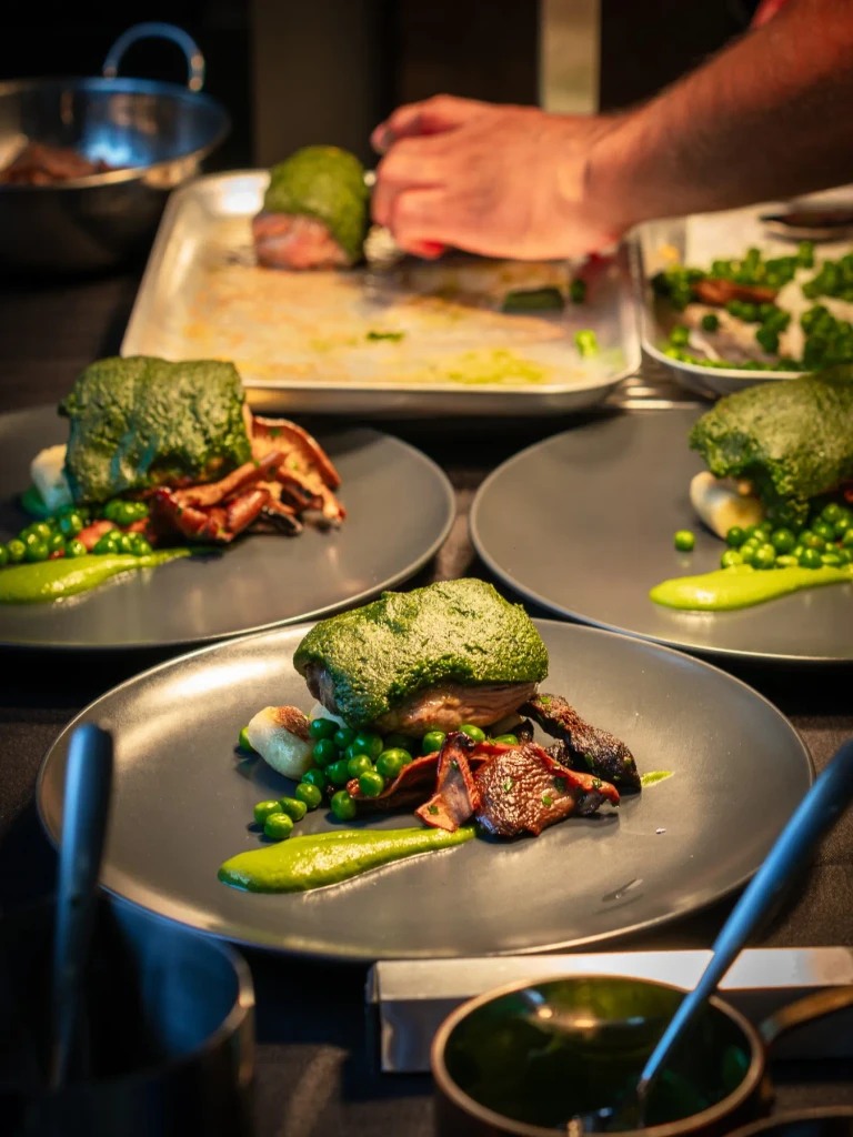 Herb crusted Herdwick lamb mains being finished on the pass