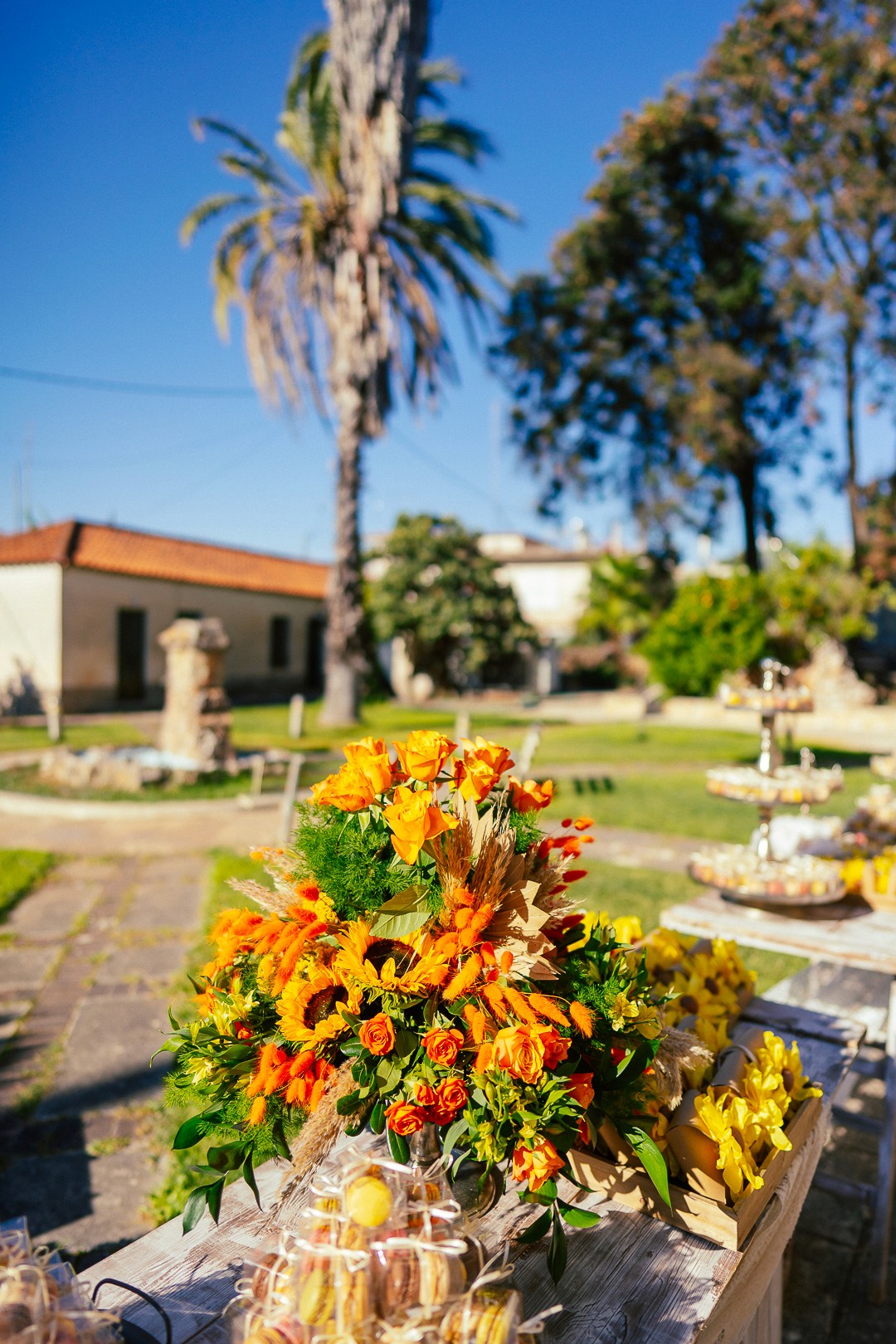Vibrant yellow and orange sunflower arrangement for an outdoor summer wedding setup