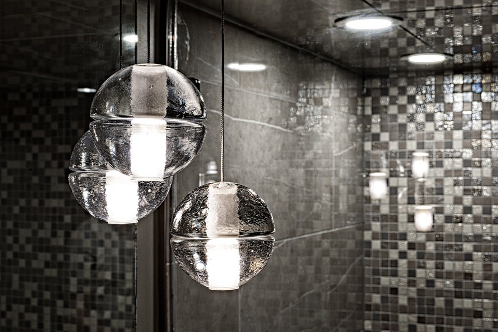 Image of Luxury bathroom interior design featuring spherical glass pendant lights and tiled spa bathroom by KHD Homes.