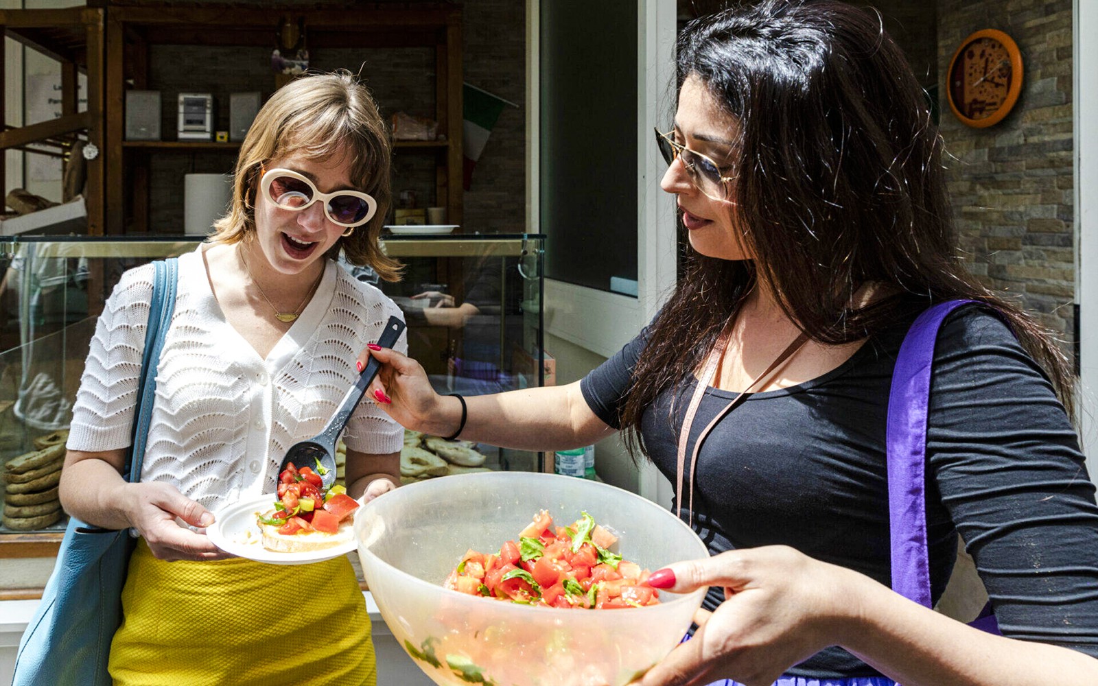 Two women enjoying tomato salad during Food & Market Tour.
