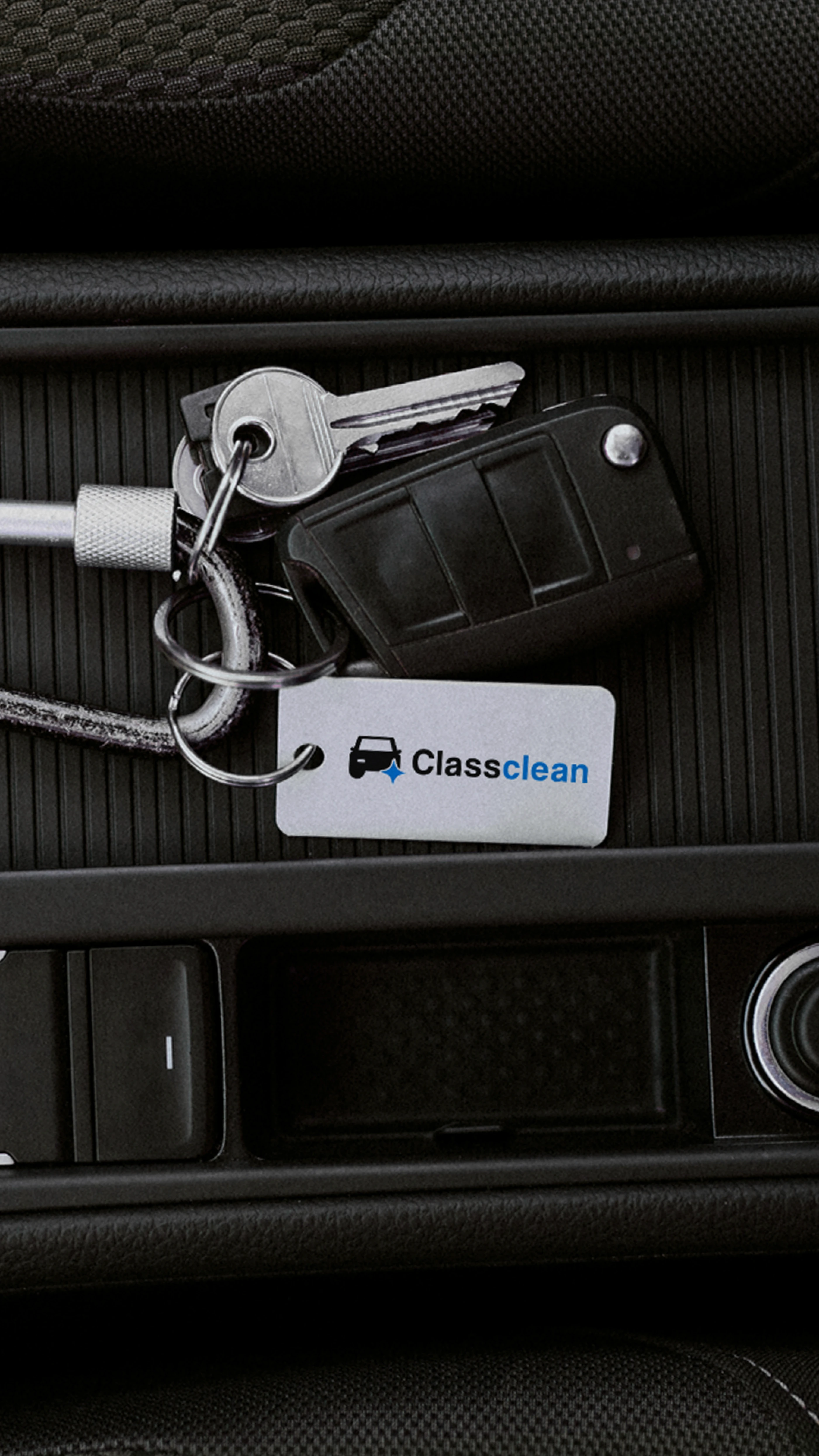 Porte-clés avec jeton personnalisé au logo Classclean posé dans l'habitacle d'une voiture.