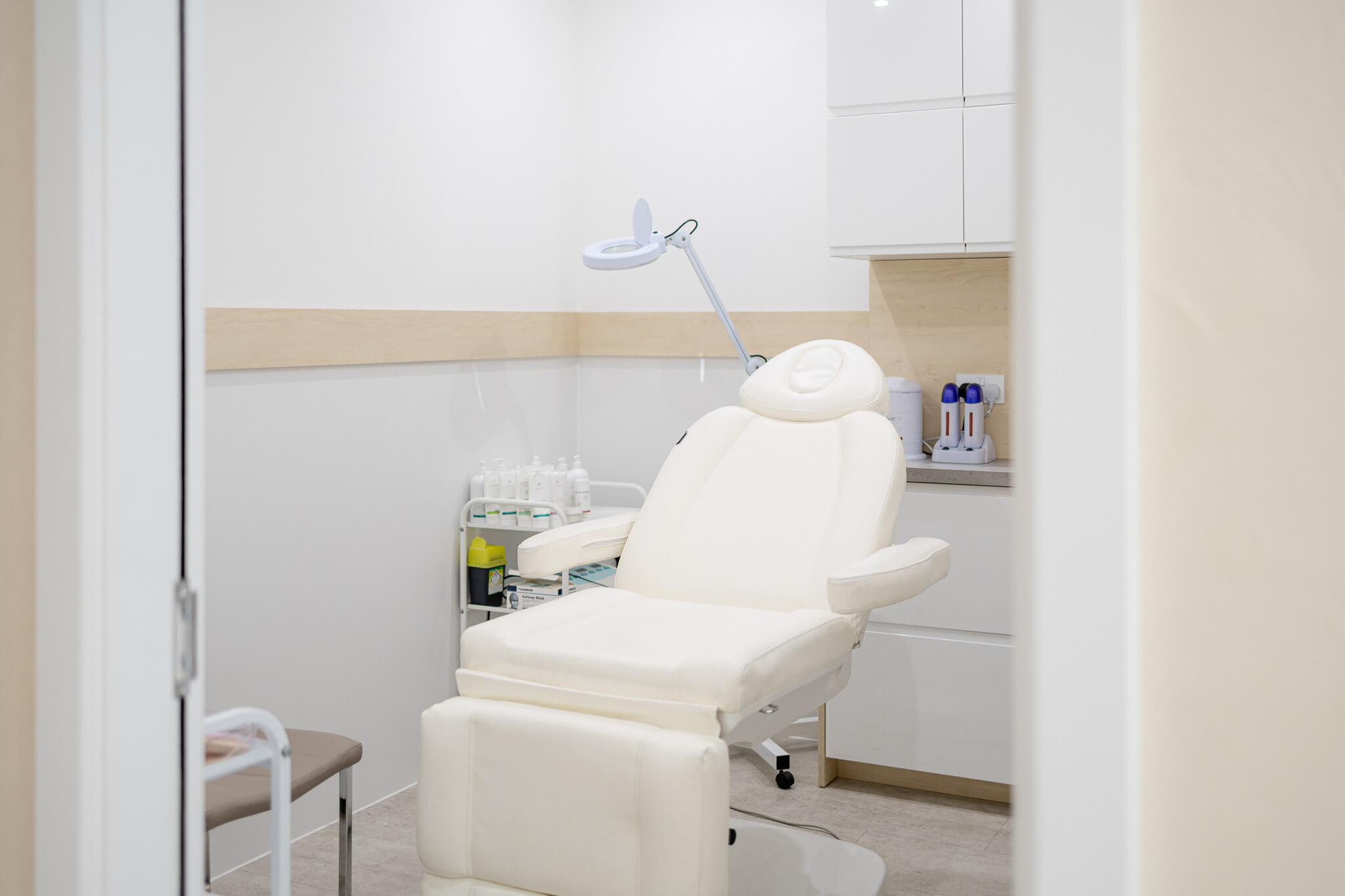 Private beauty treatment room with aesthetic chair and skincare equipment.
