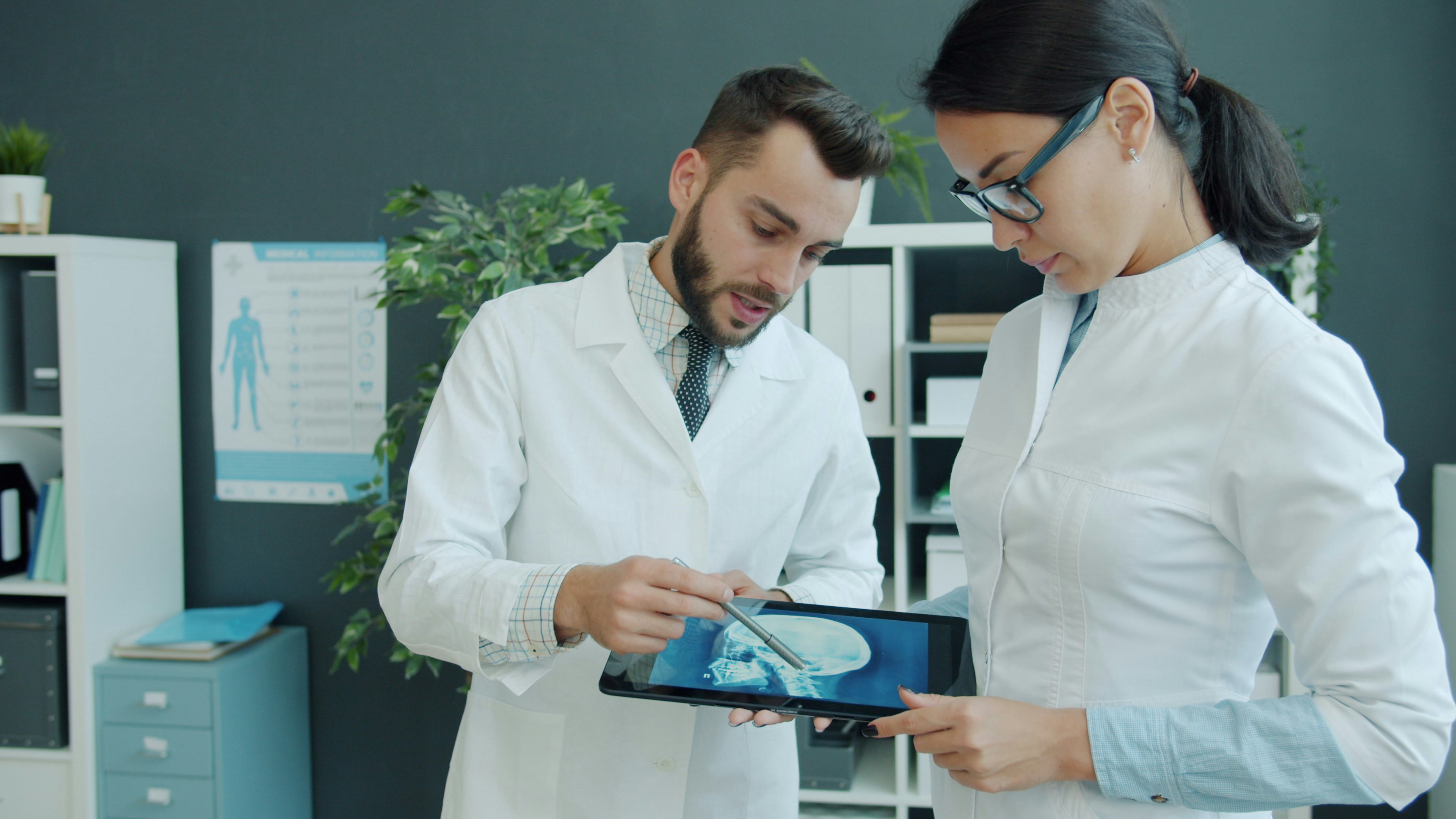 Two doctors looking at a medical scan on tablet
