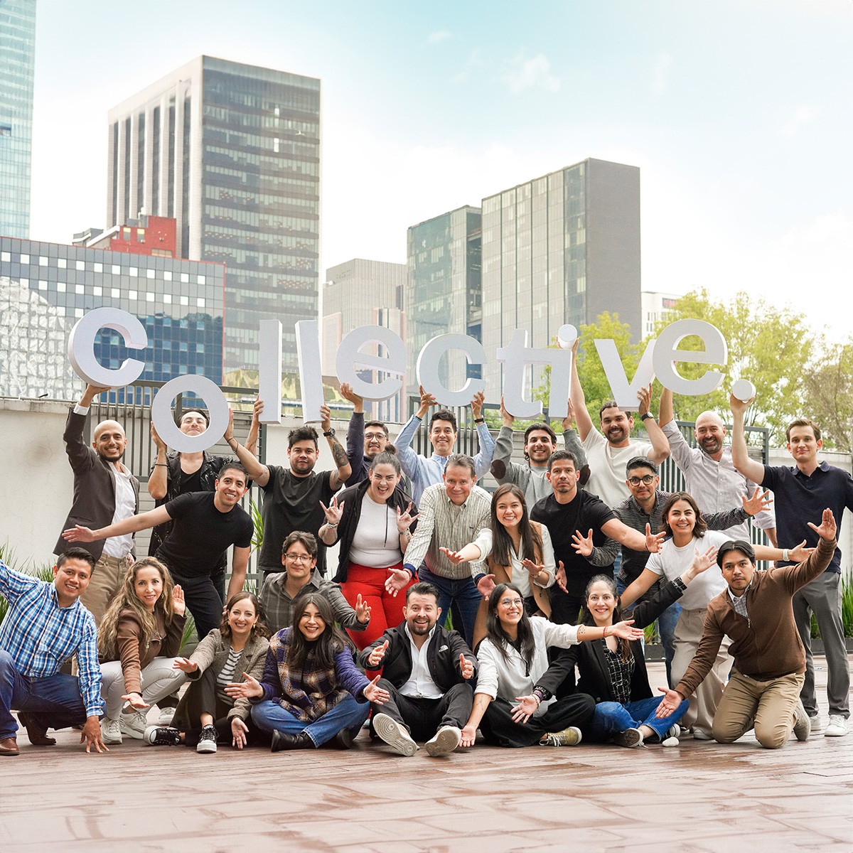 A modern office workspace with a wooden desk, laptop, notebooks, and potted plants by a bright window