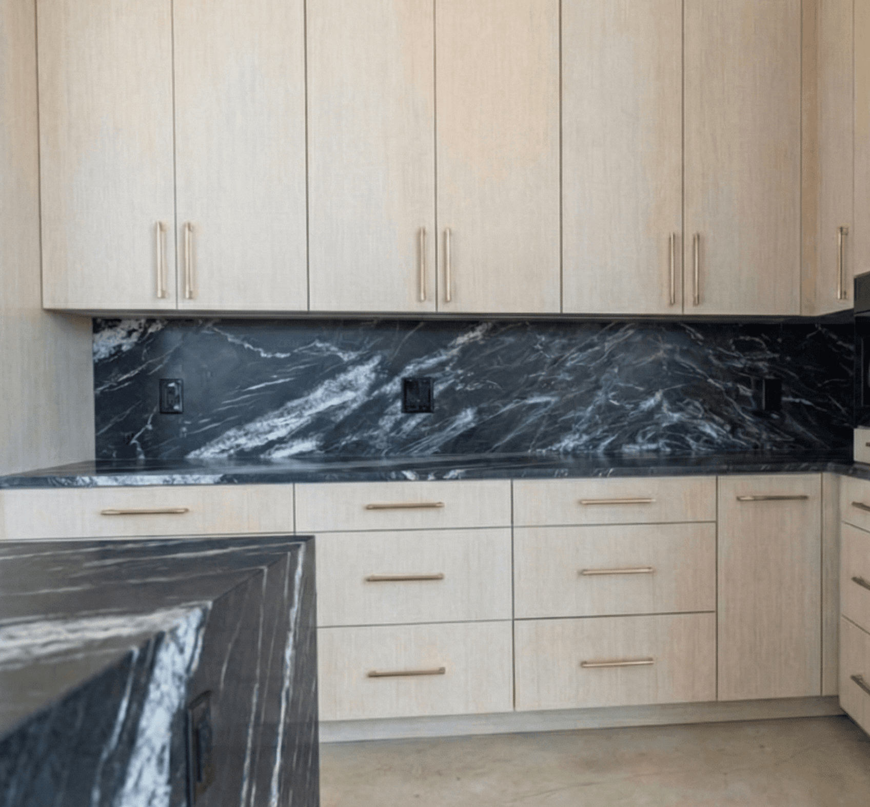 black granite countertop installation with waterfall island in dallas fort worth modern gold handles and hardware