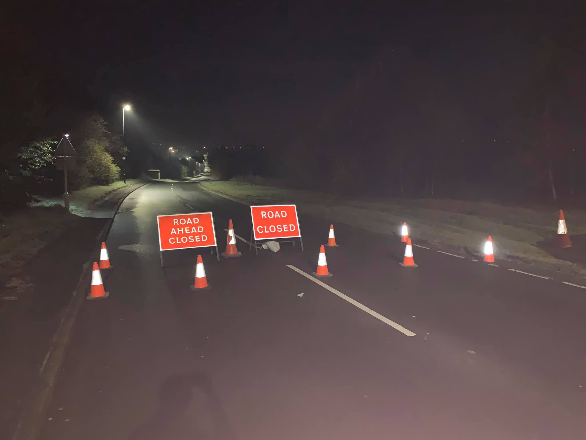 Road closed sign on a highway at night, symbolizing upcoming closures and diversions for logistics routes.