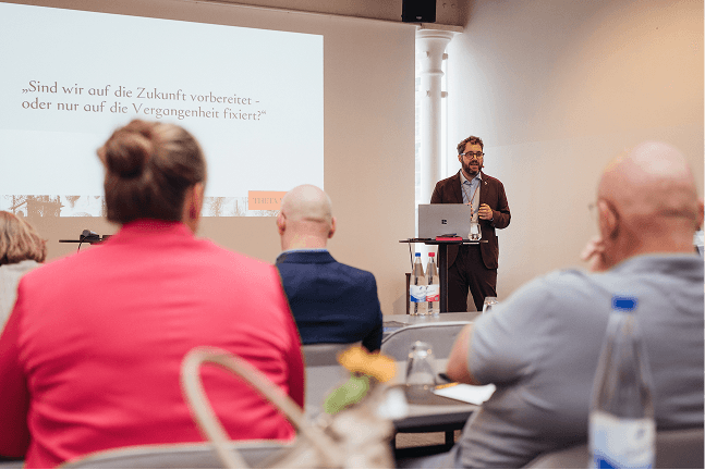 Prof. Dr. Dr. Oliver Hoffmann steht vor den Teilnehmern im Seminar