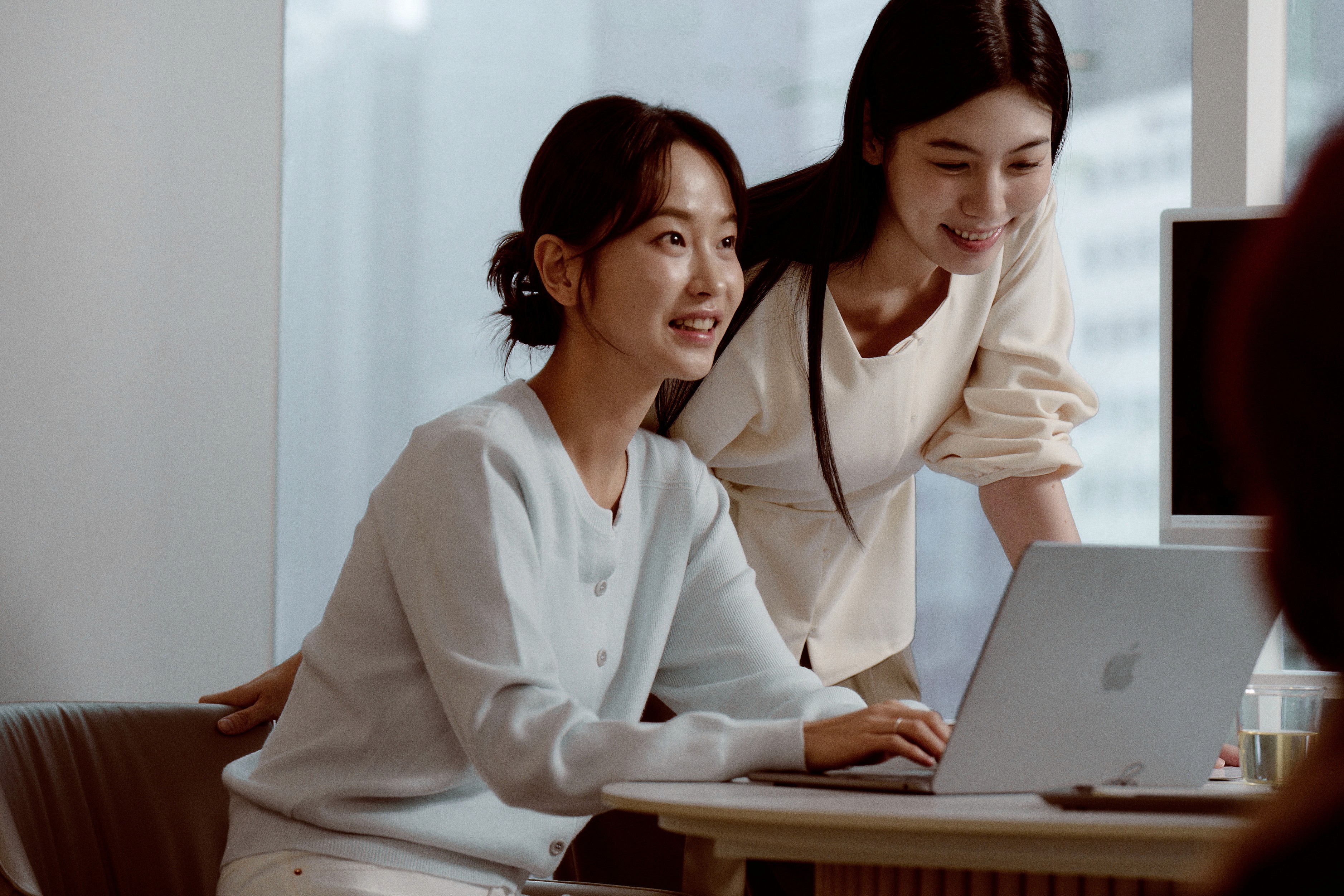Two students smiling during a language learning session at 612 Academy, reflecting an engaging and human-centered learning experience.