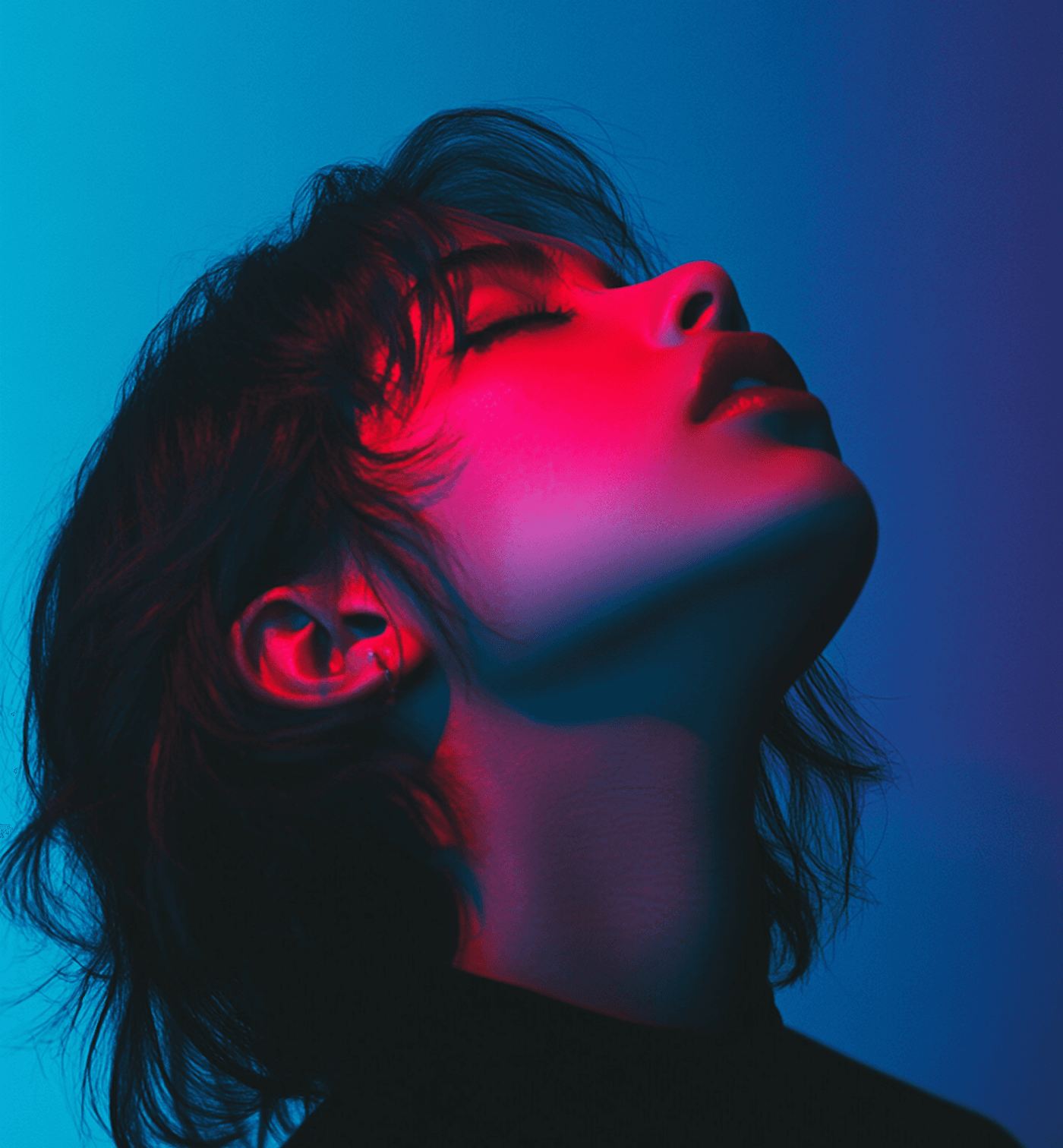 A woman with closed eyes is illuminated by a bright blue light, creating a serene and tranquil atmosphere.