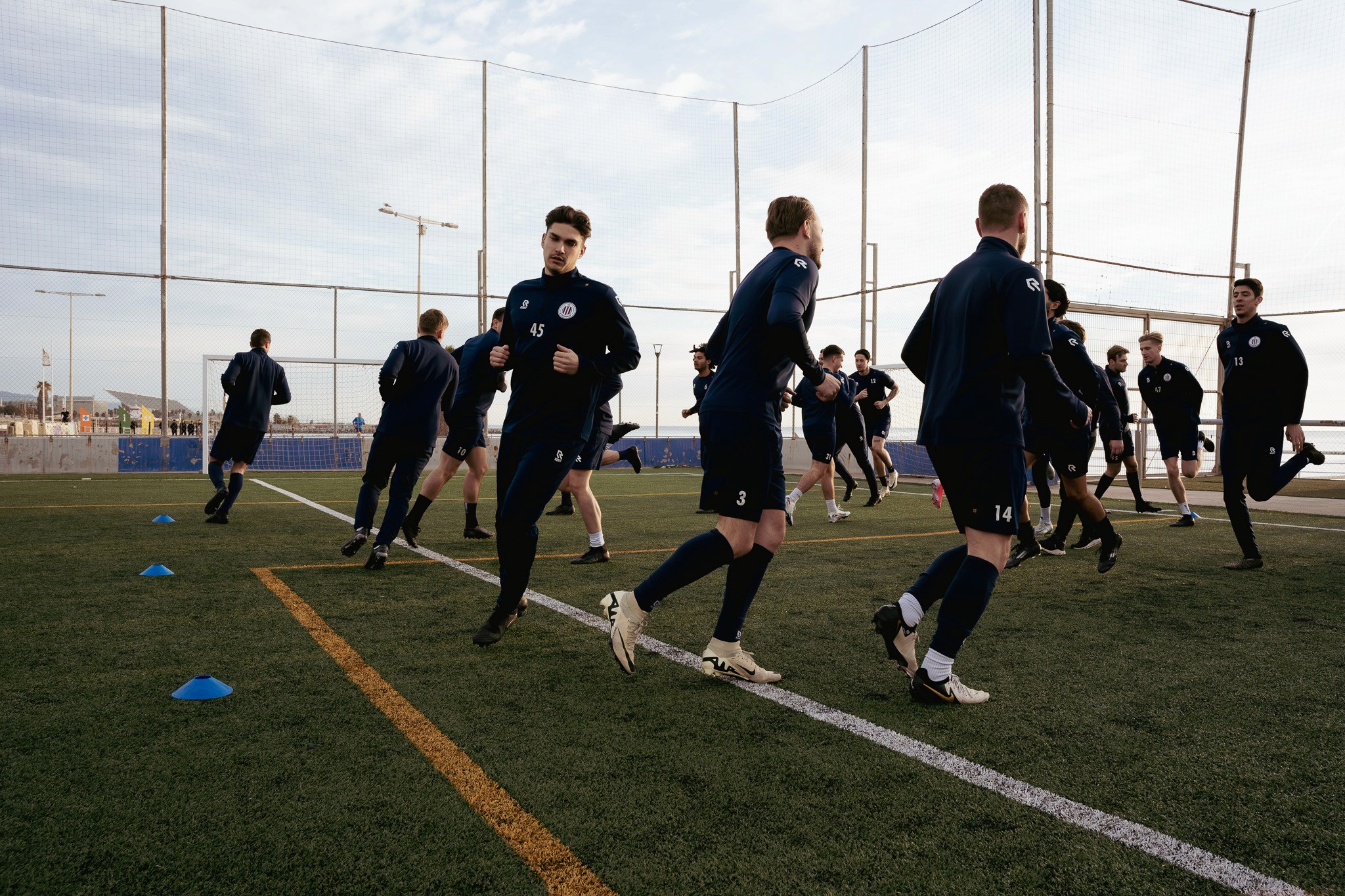 Voetbalteam uit Nederland tijdens trainingskamp op voetbalveld in Barcelona