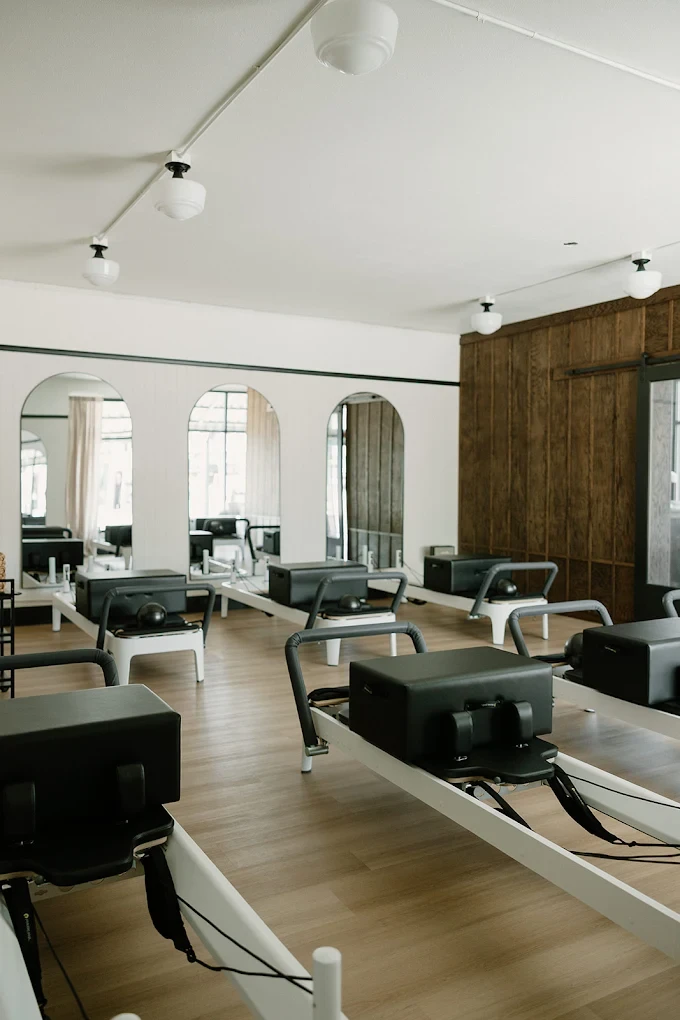 Pilates reformer studio at The Press Pilates featuring aligned machines, arched mirrors, and a calm, design-led interior