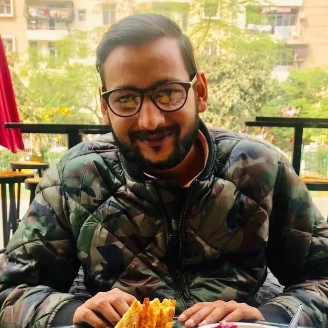 woman in black crew neck t-shirt wearing brown framed eyeglasses standing on rocky shore during