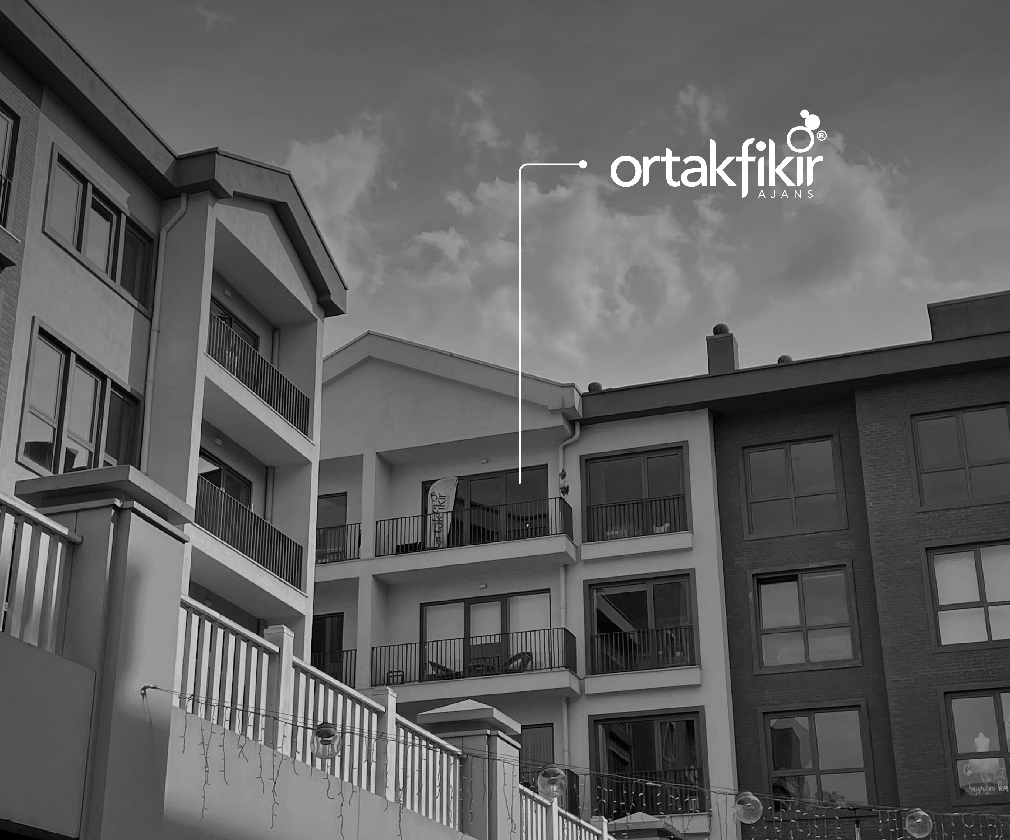 Monochrome product shot: black-capped cosmetic bottle with dynamic water splash on a clean white background.